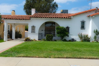 A white stucco house with a red tile roof.