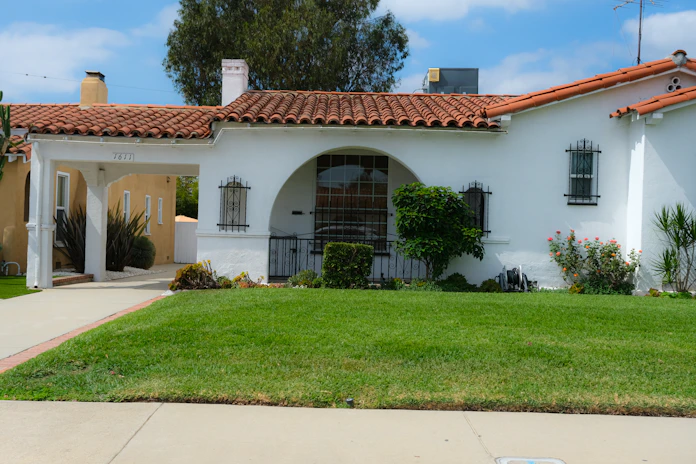 A white stucco house with a red tile roof.