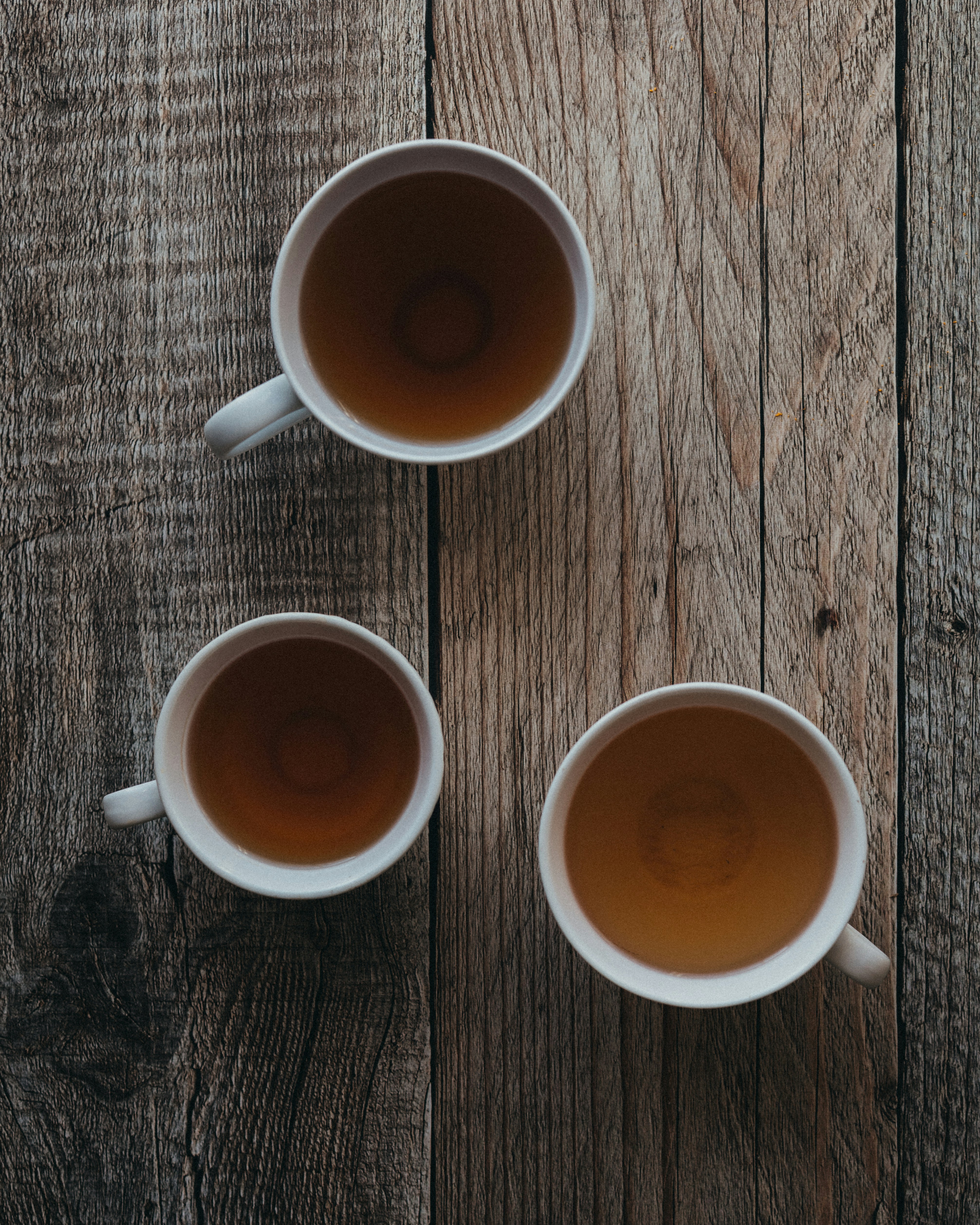 Three cups of tea on a wooden table
