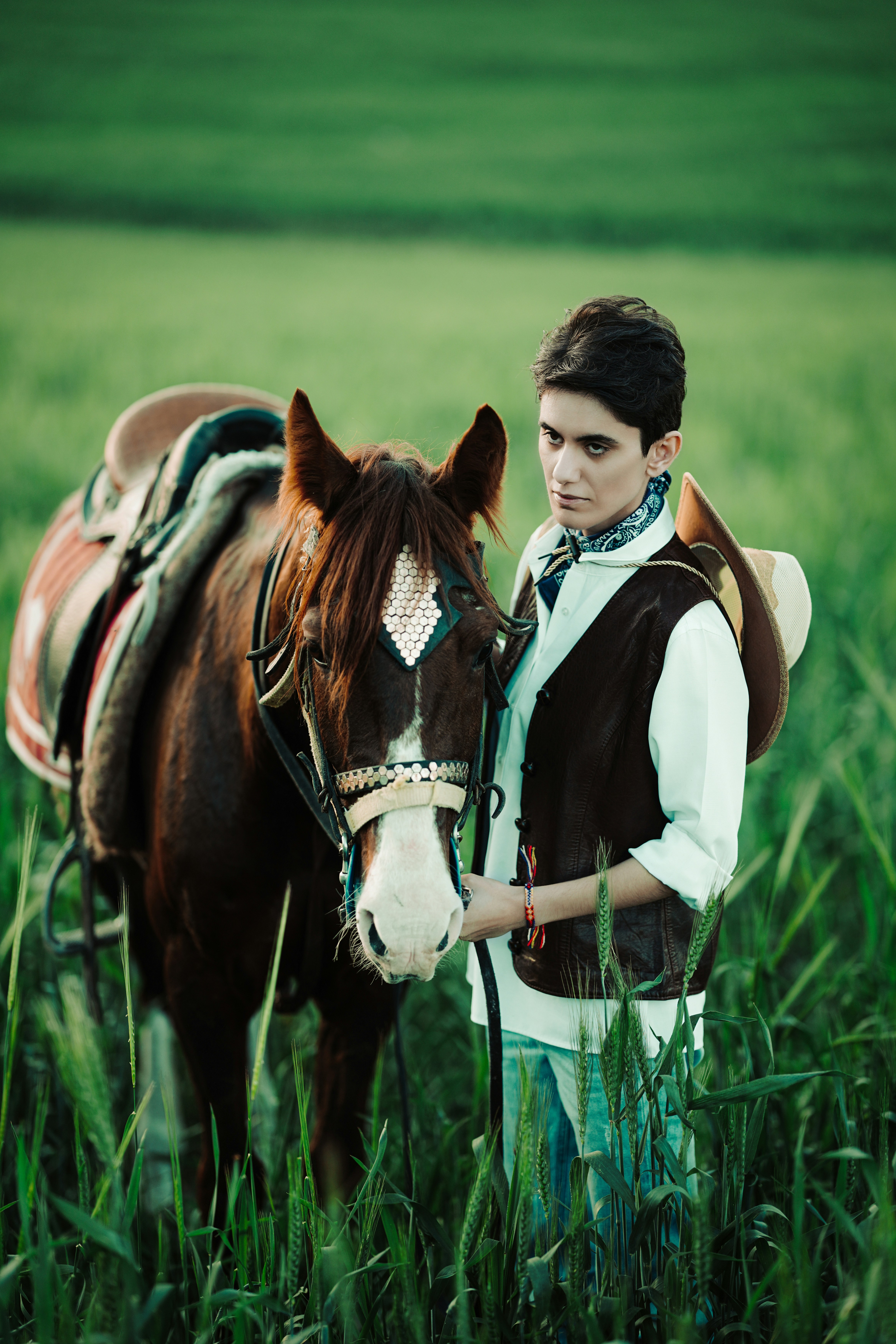 Cowboy with horse in a green field