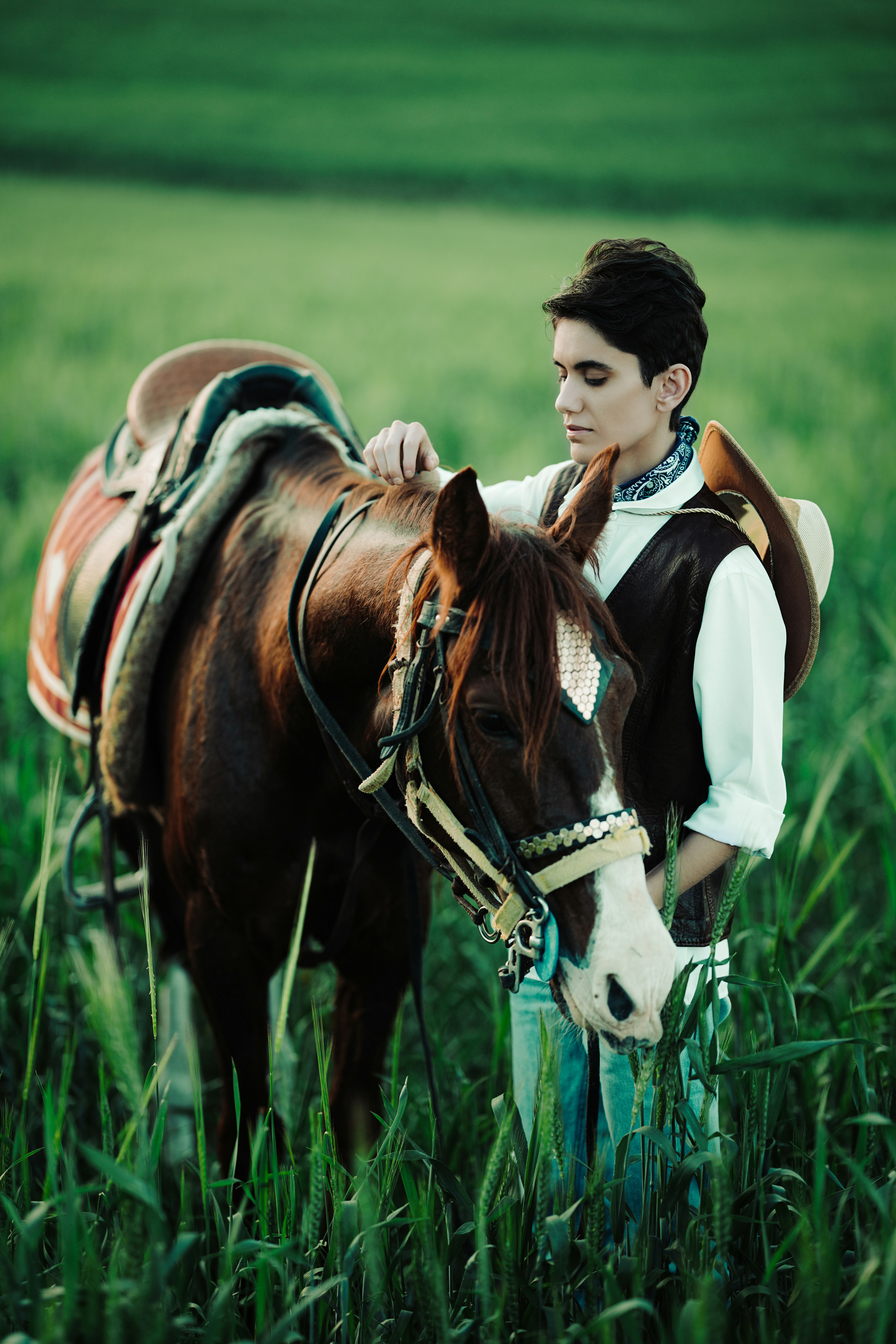 Cowboy with horse in a green field
