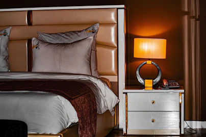 Luxurious bedroom with a lit bedside lamp.