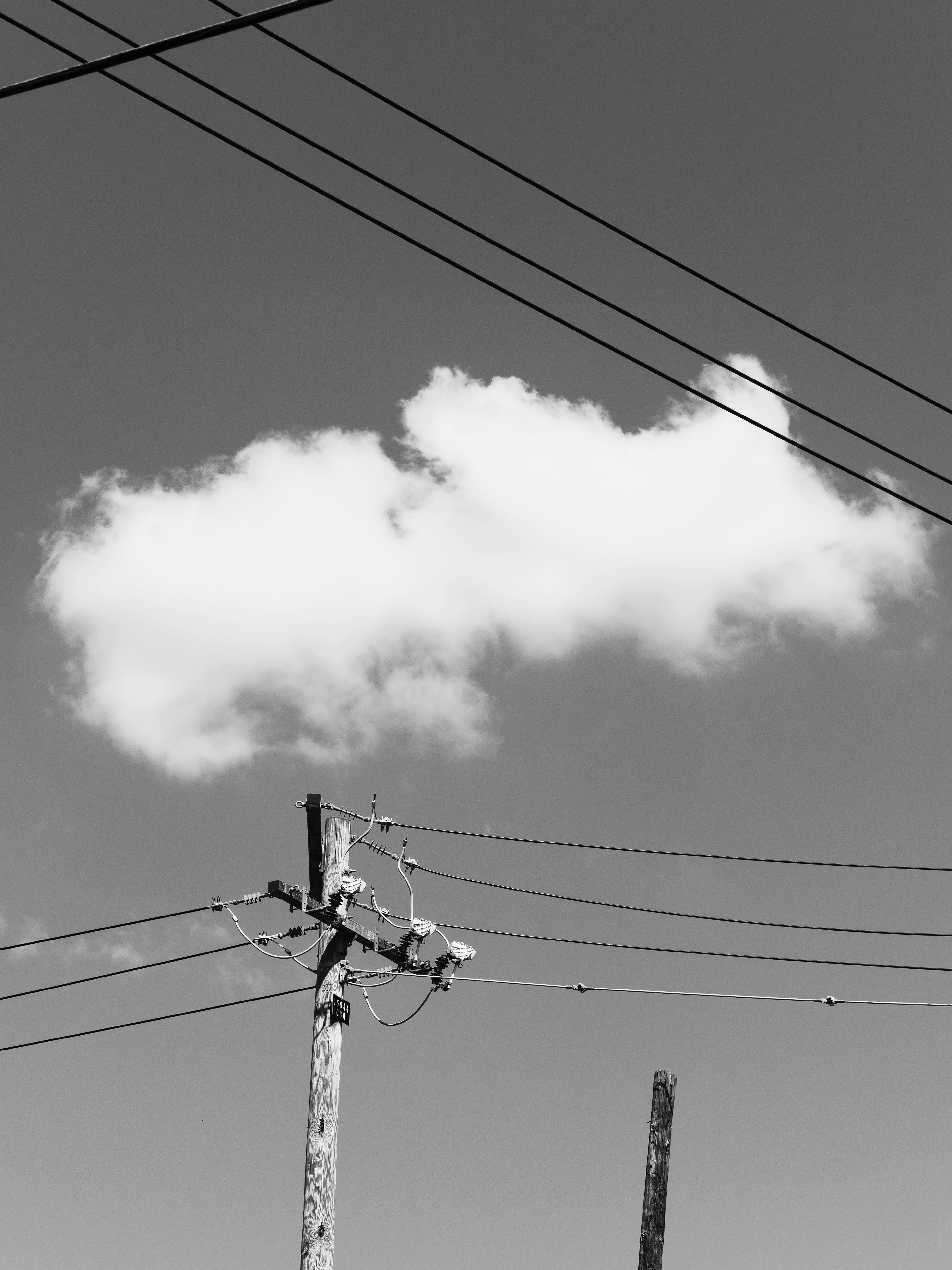 Poste telefónico con cables contra un cielo nublado