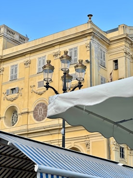 Ornate street lamp against a yellow building facade.