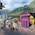 Colorful street art adorns buildings in a hilly city neighborhood.