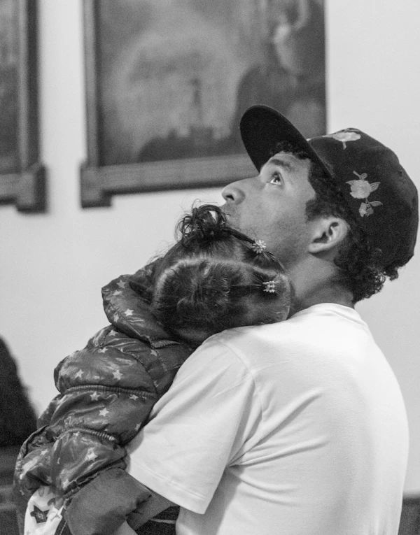 Man holding a child, looking up protectively