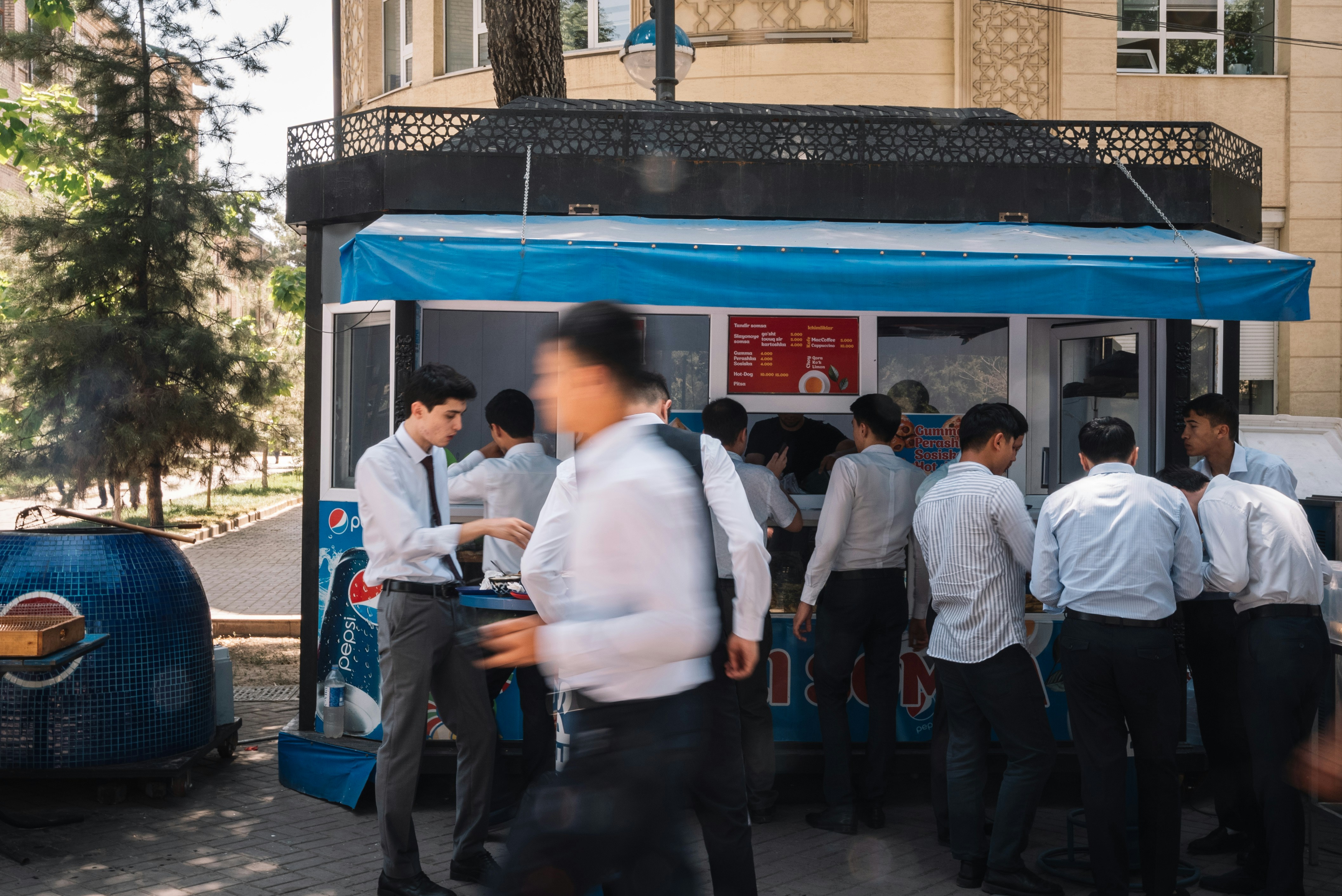 People lining up at a blue food stand.