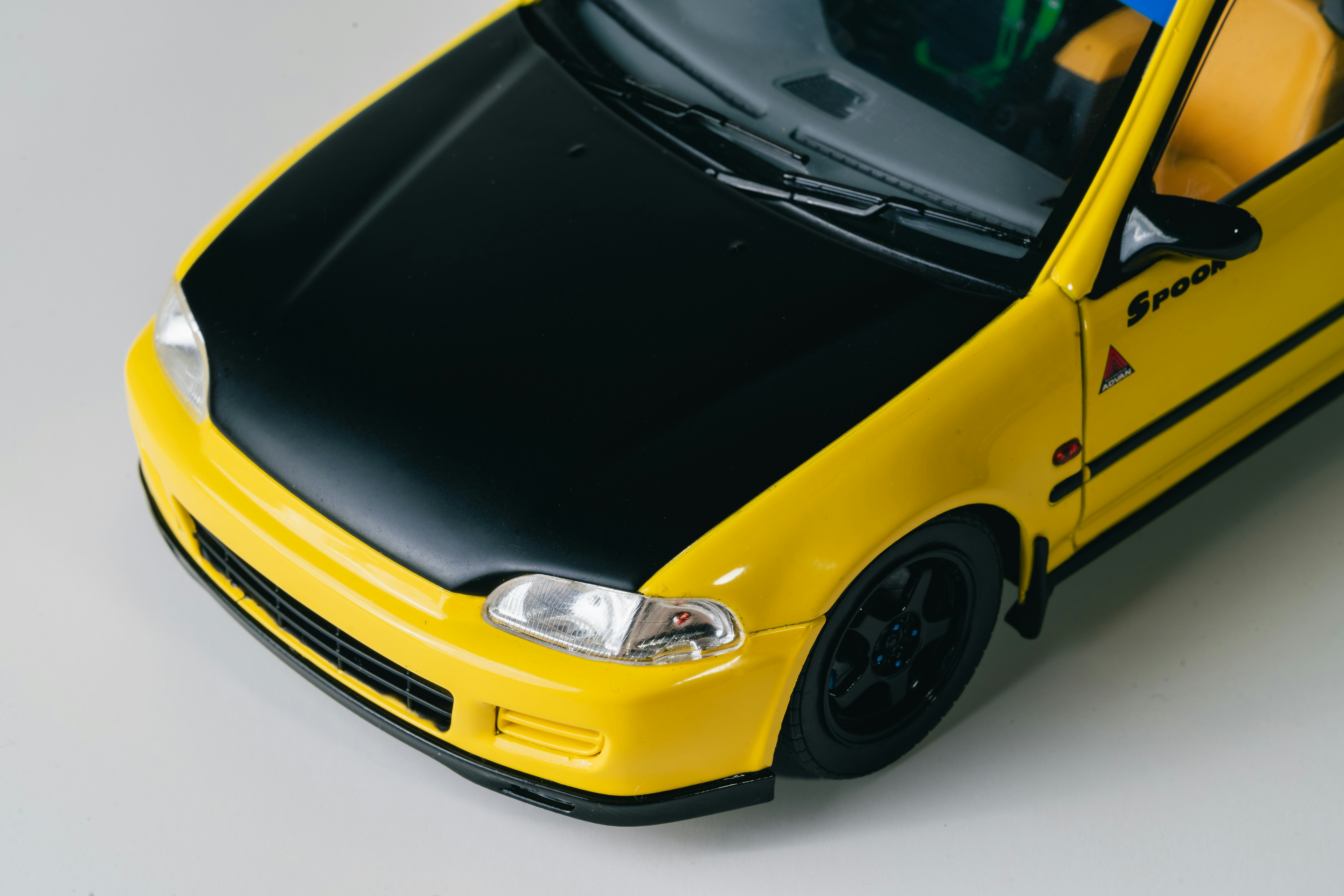 Yellow car with black hood and black wheels representing custom professional solutions