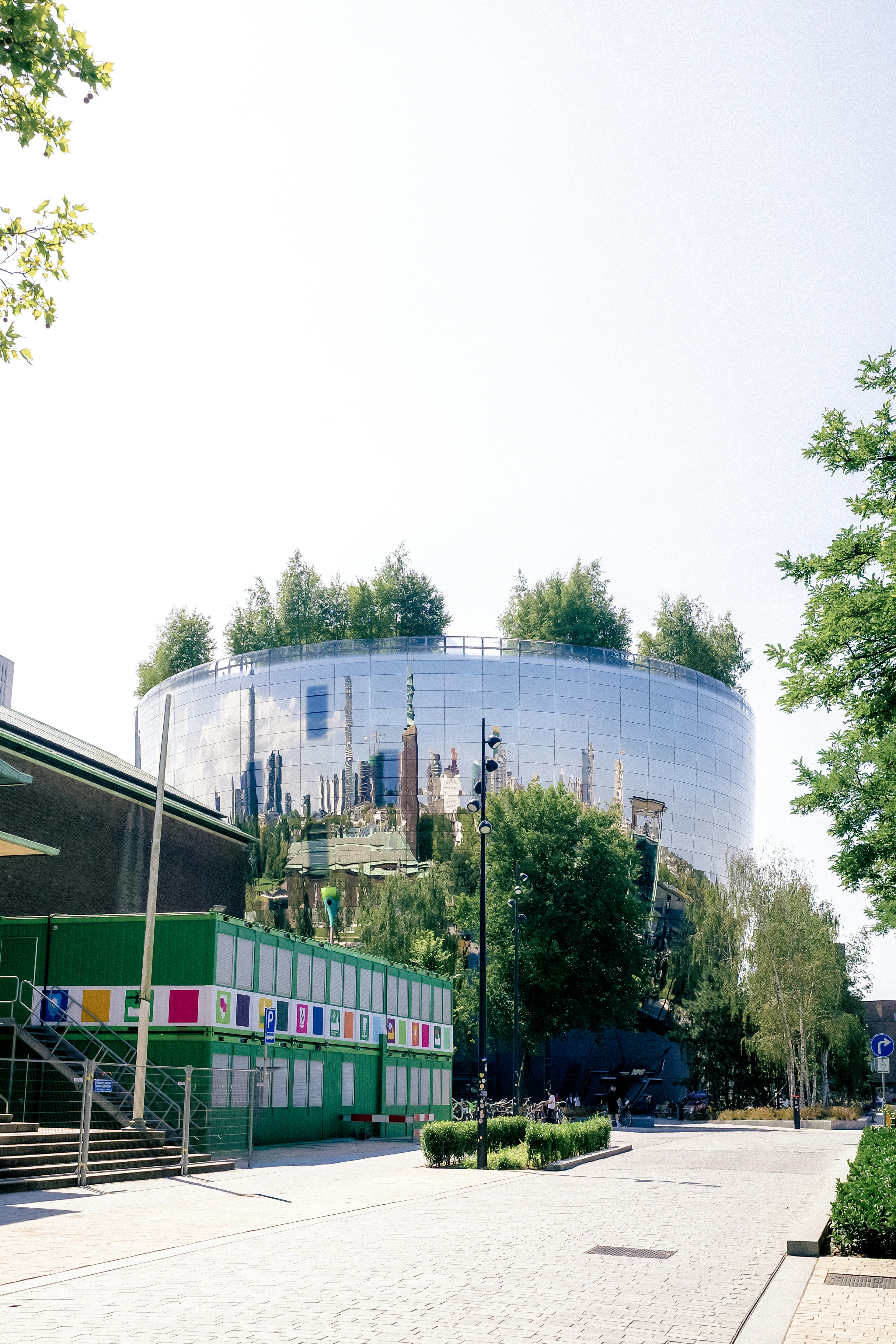 Modern building with reflective glass and rooftop trees