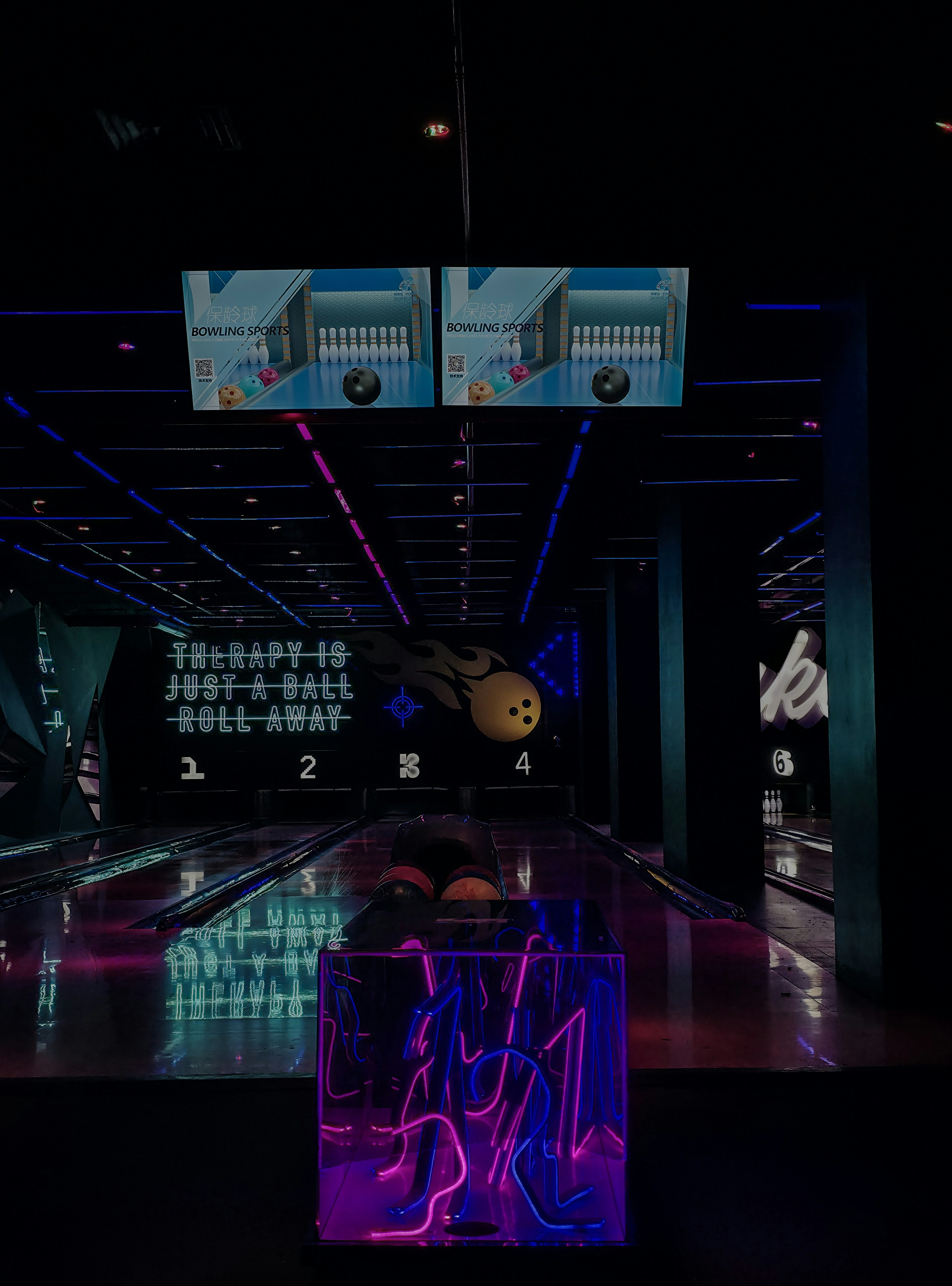 Neon-lit bowling alley with lanes and pins.