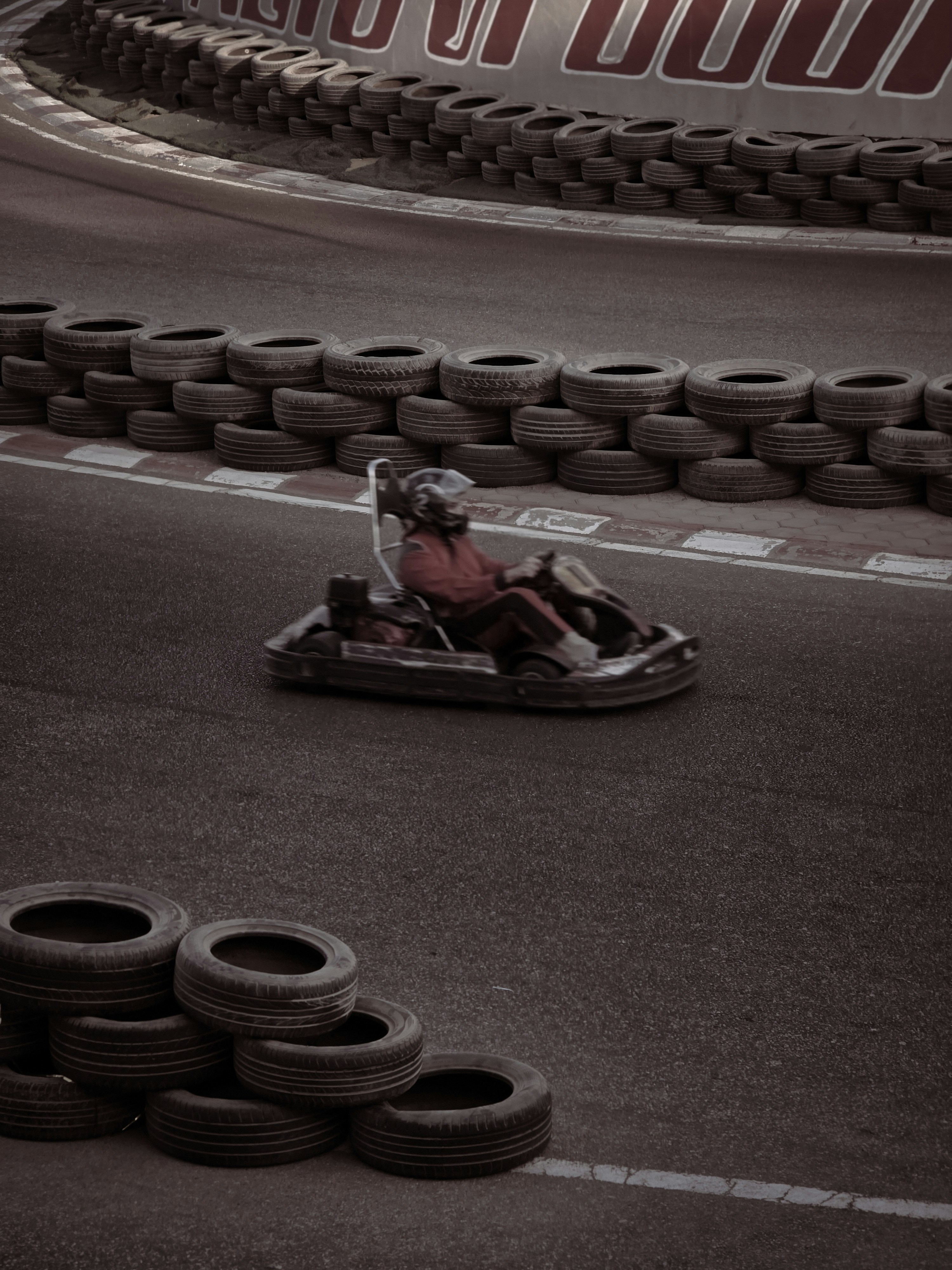 Go-kart racer on a track with tire barriers