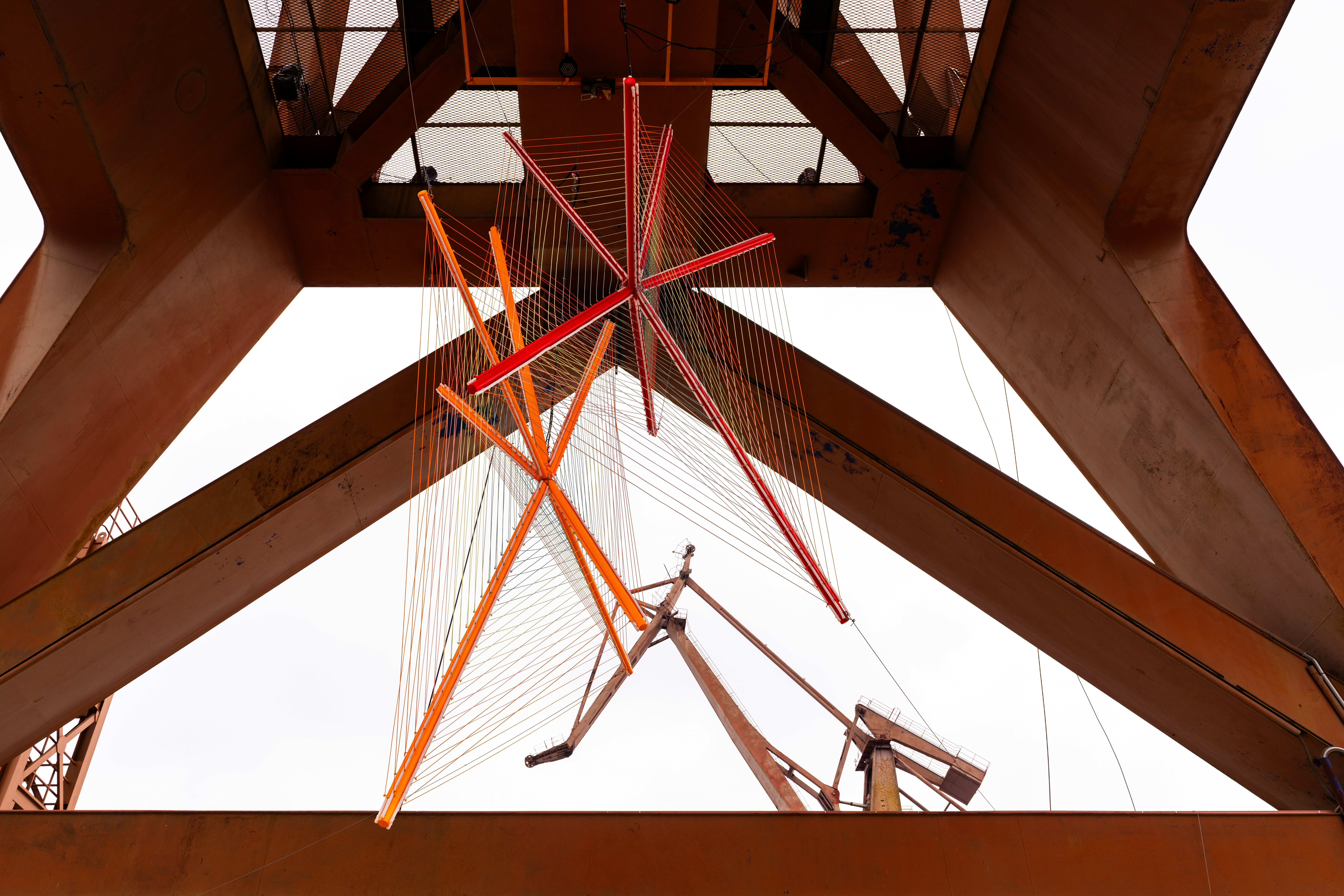 Abstract sculpture hanging from industrial structure