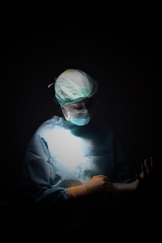 Surgeon in scrubs preparing for operation in operating room.