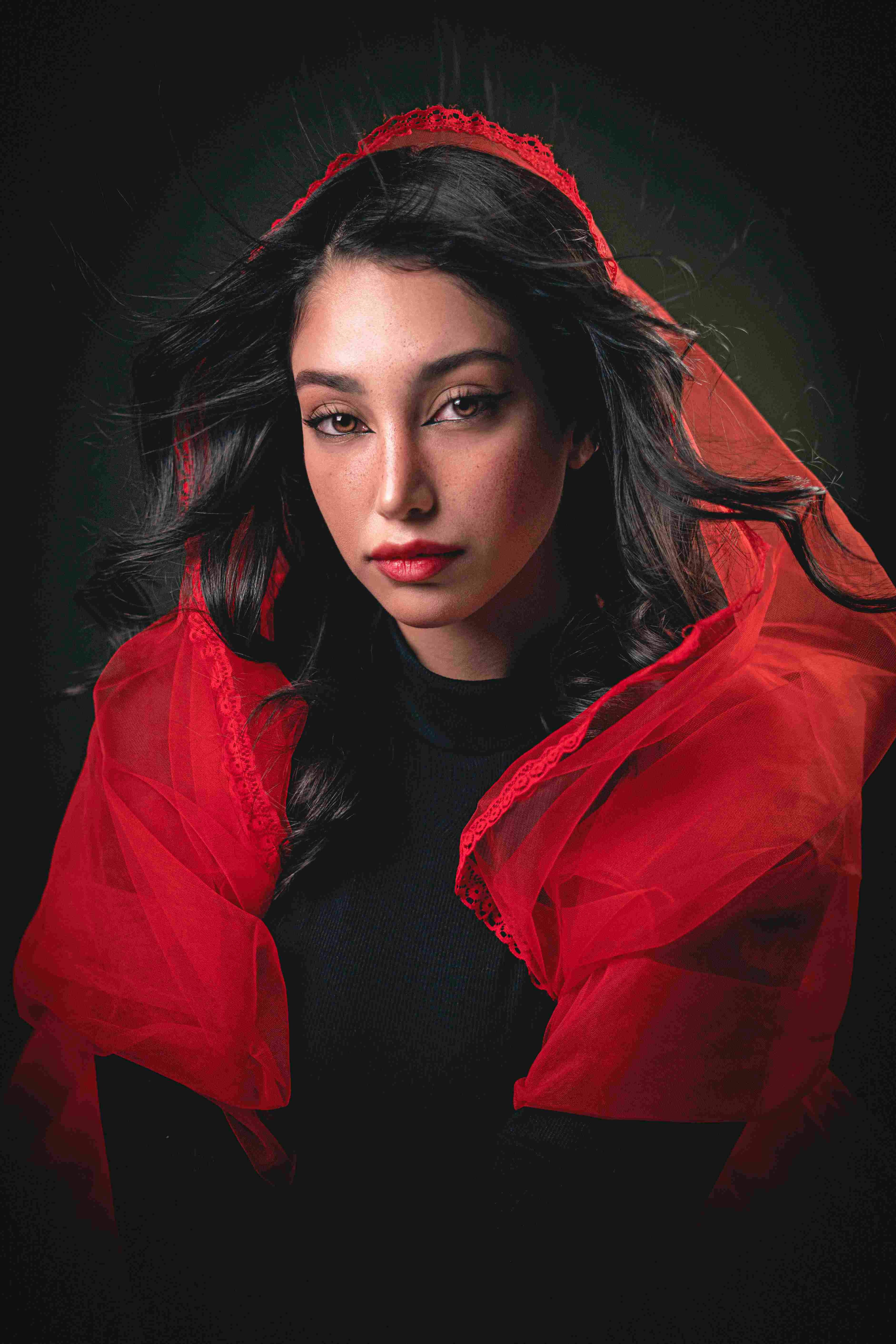 Woman with dark hair and red veil