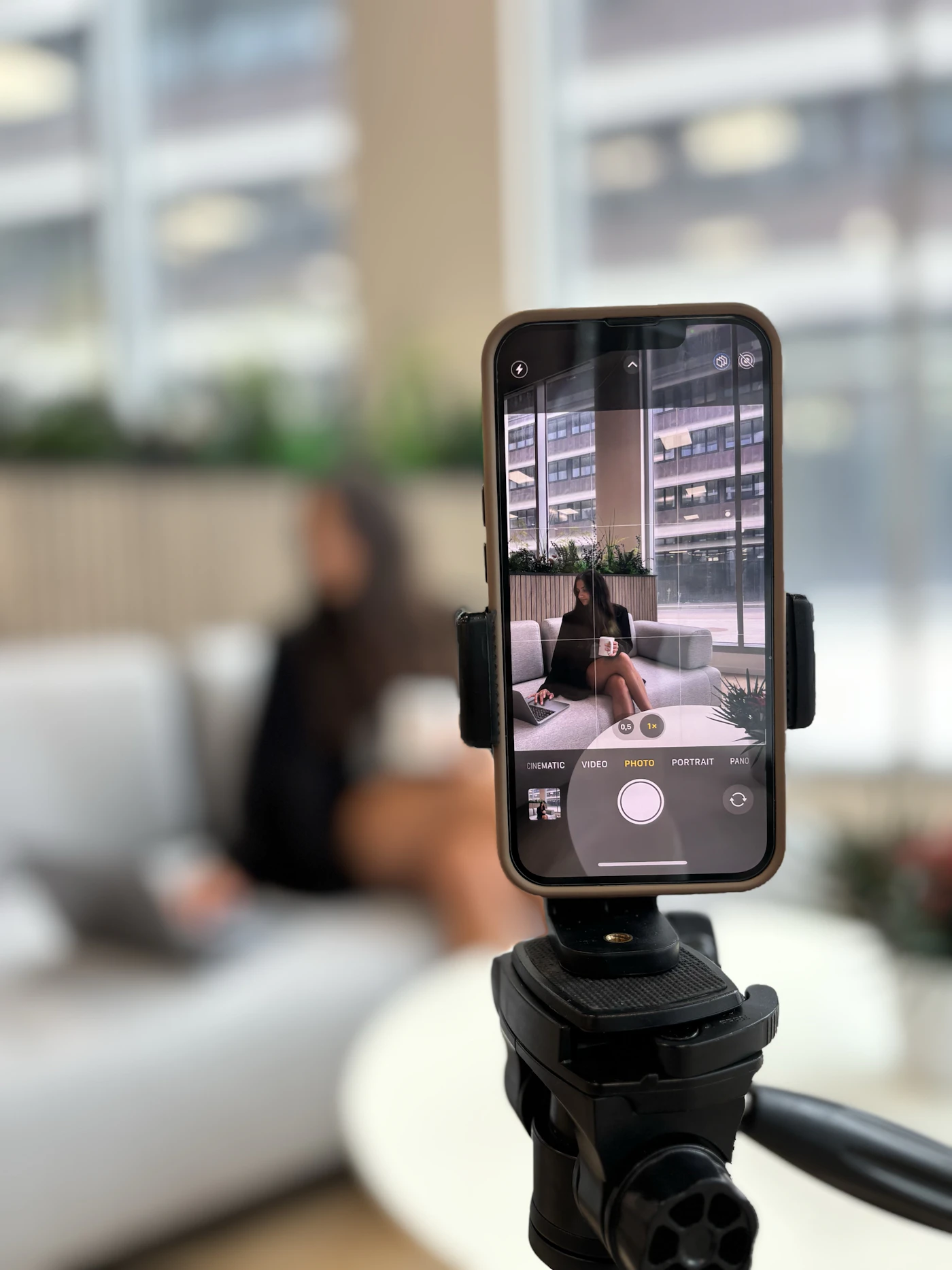 Smartphone on a stand recording a woman on a couch for an Instagram Reels ad