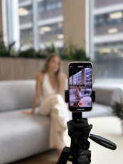 Woman recording herself on a smartphone tripod