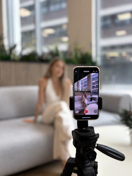 Woman recording herself on a smartphone tripod