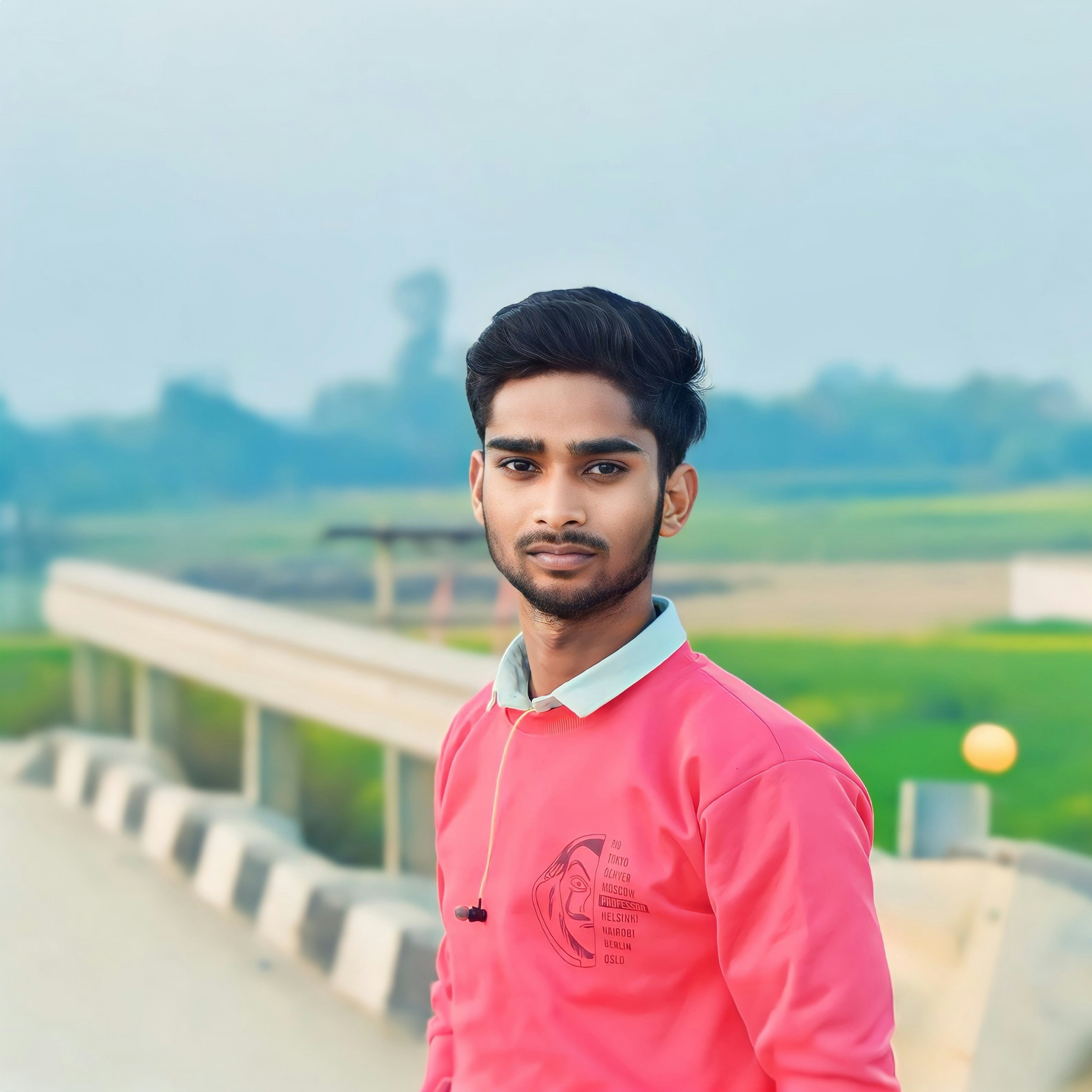 Young man in pink sweatshirt looking at camera