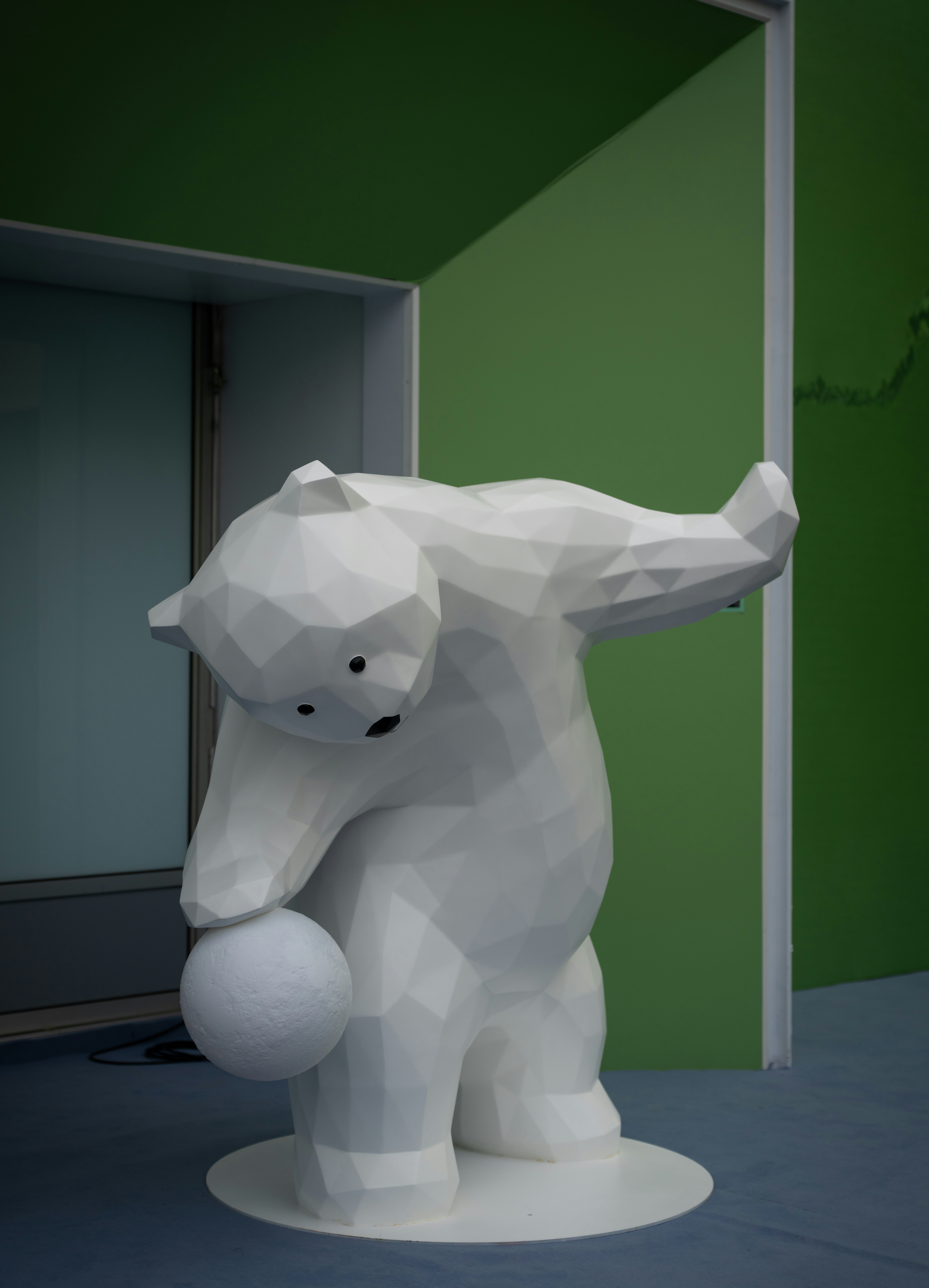 White polygonal bear statue holding a sphere