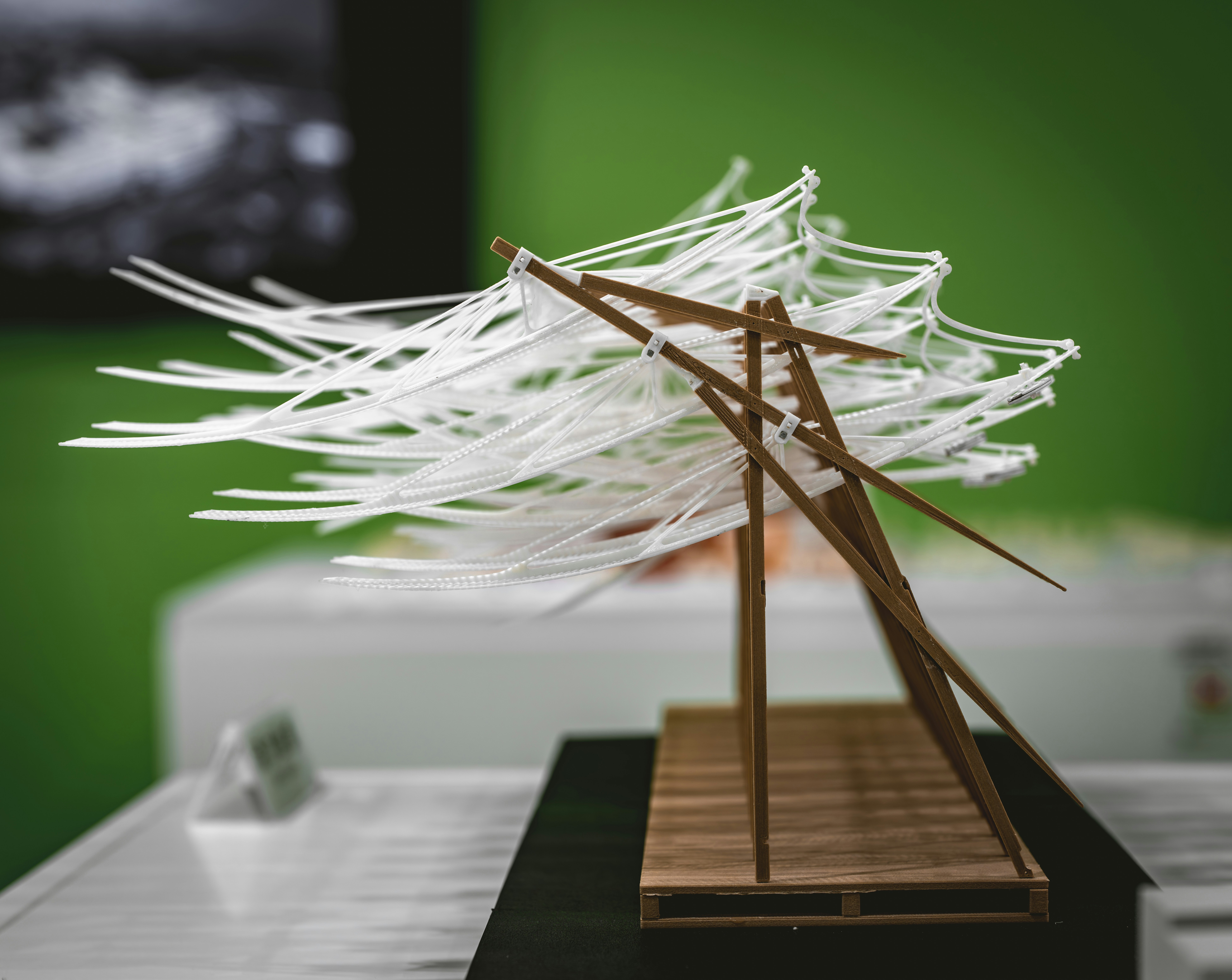 Architectural model with white strings and wooden structure.