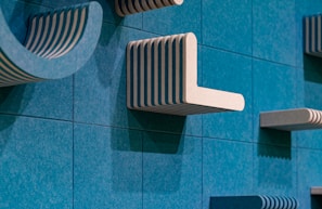 Abstract blue wall with white and green striped shelves.