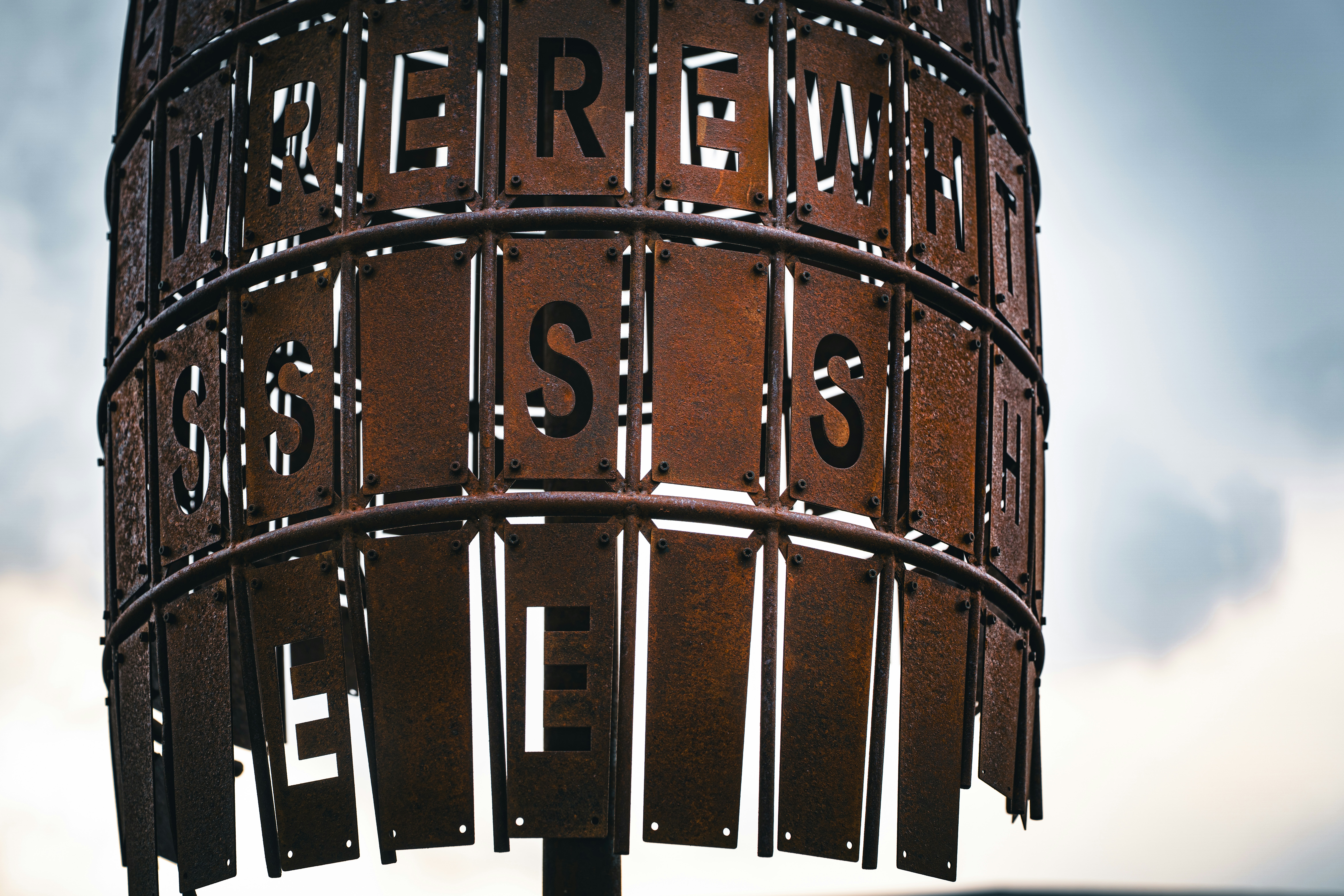 切り抜き文字の錆びた金属彫刻