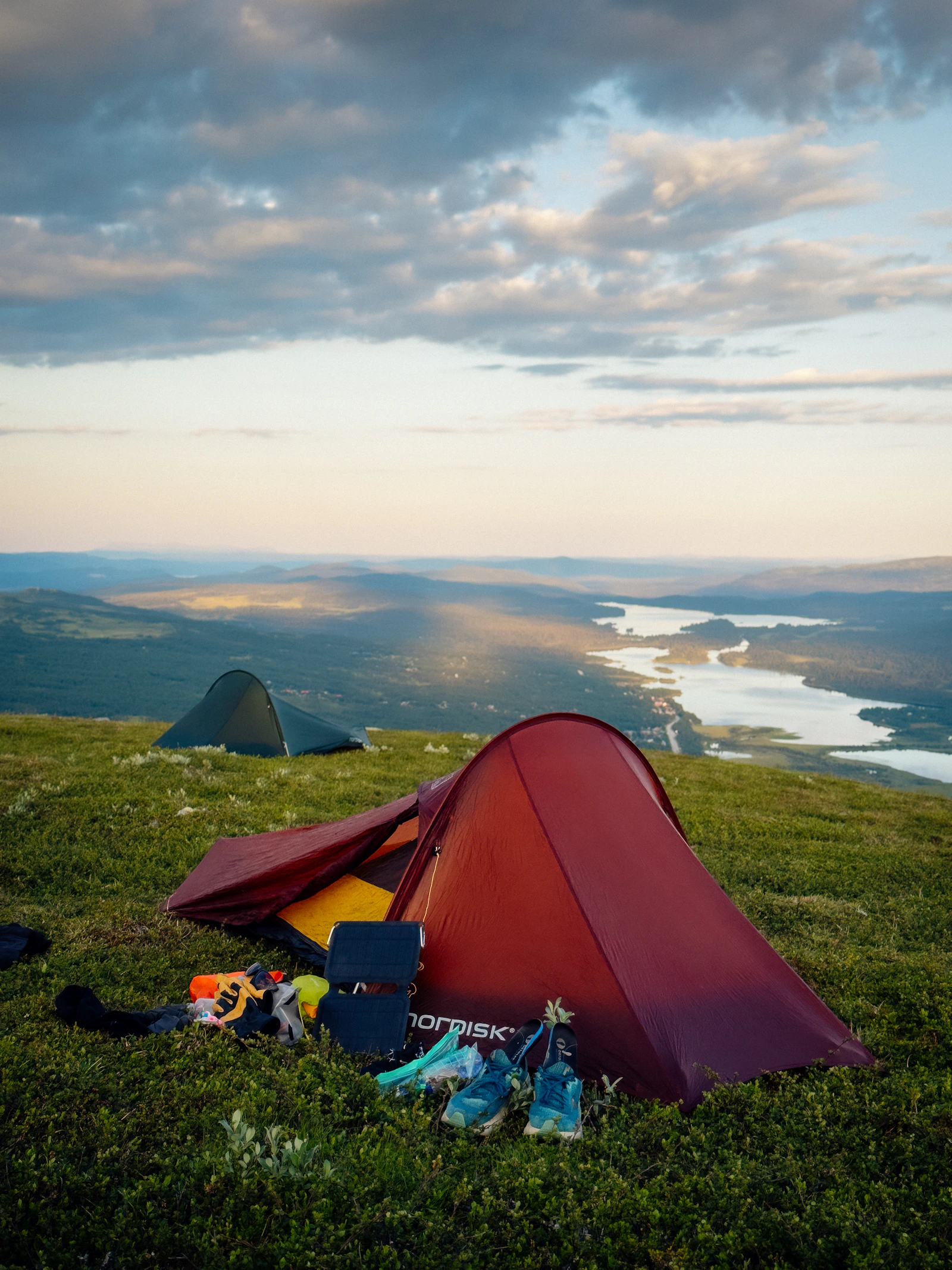 Camping tents overlooking a lake and mountain landscape