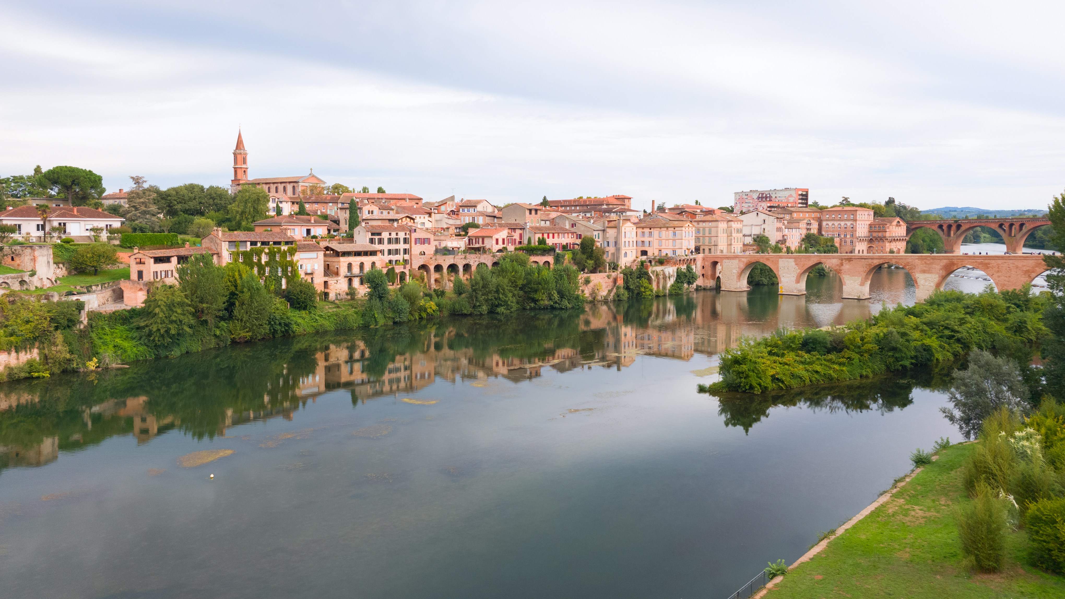River flowing past a historic european town with bridge.