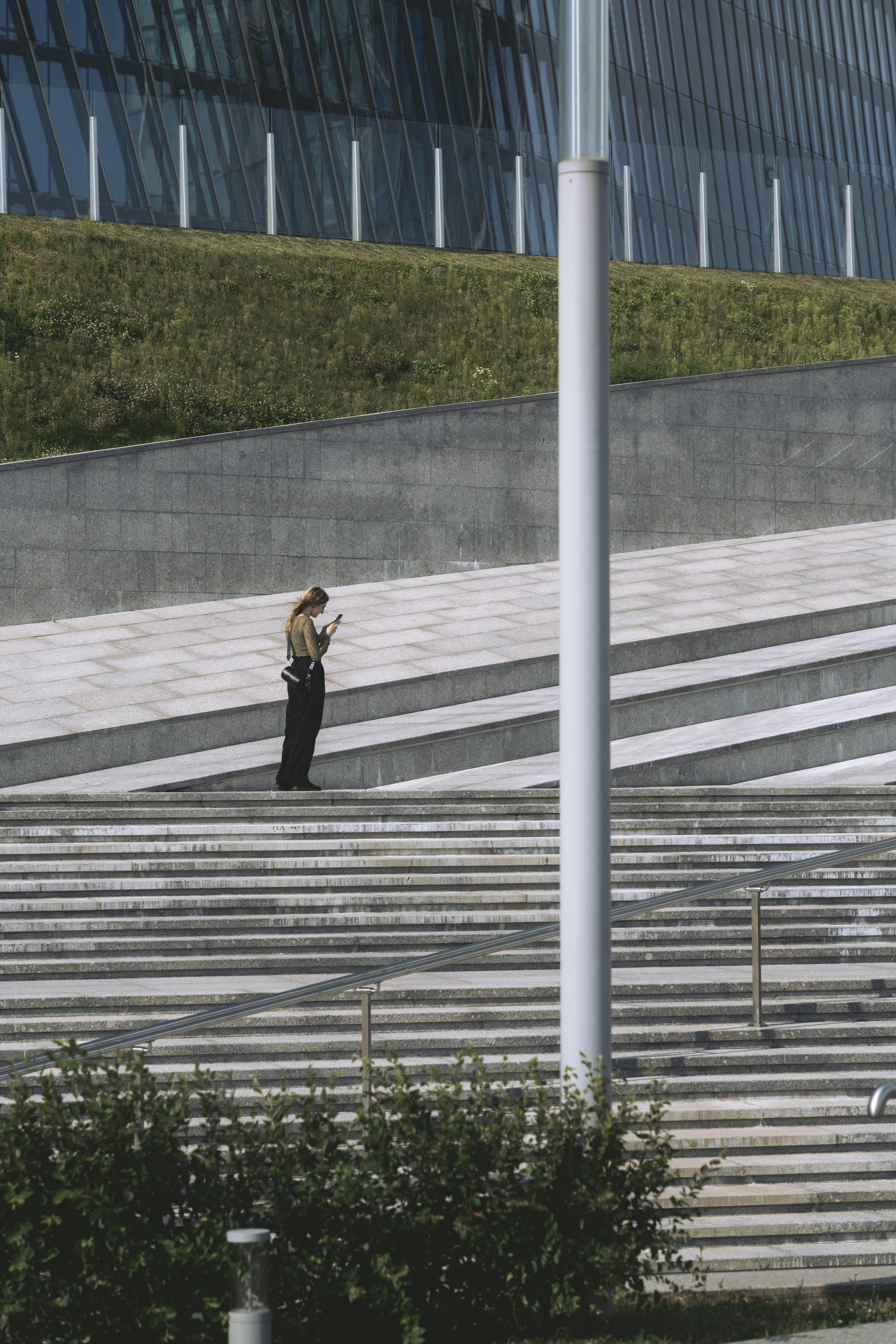 Femme dans les escaliers extérieurs utilisant son téléphone.