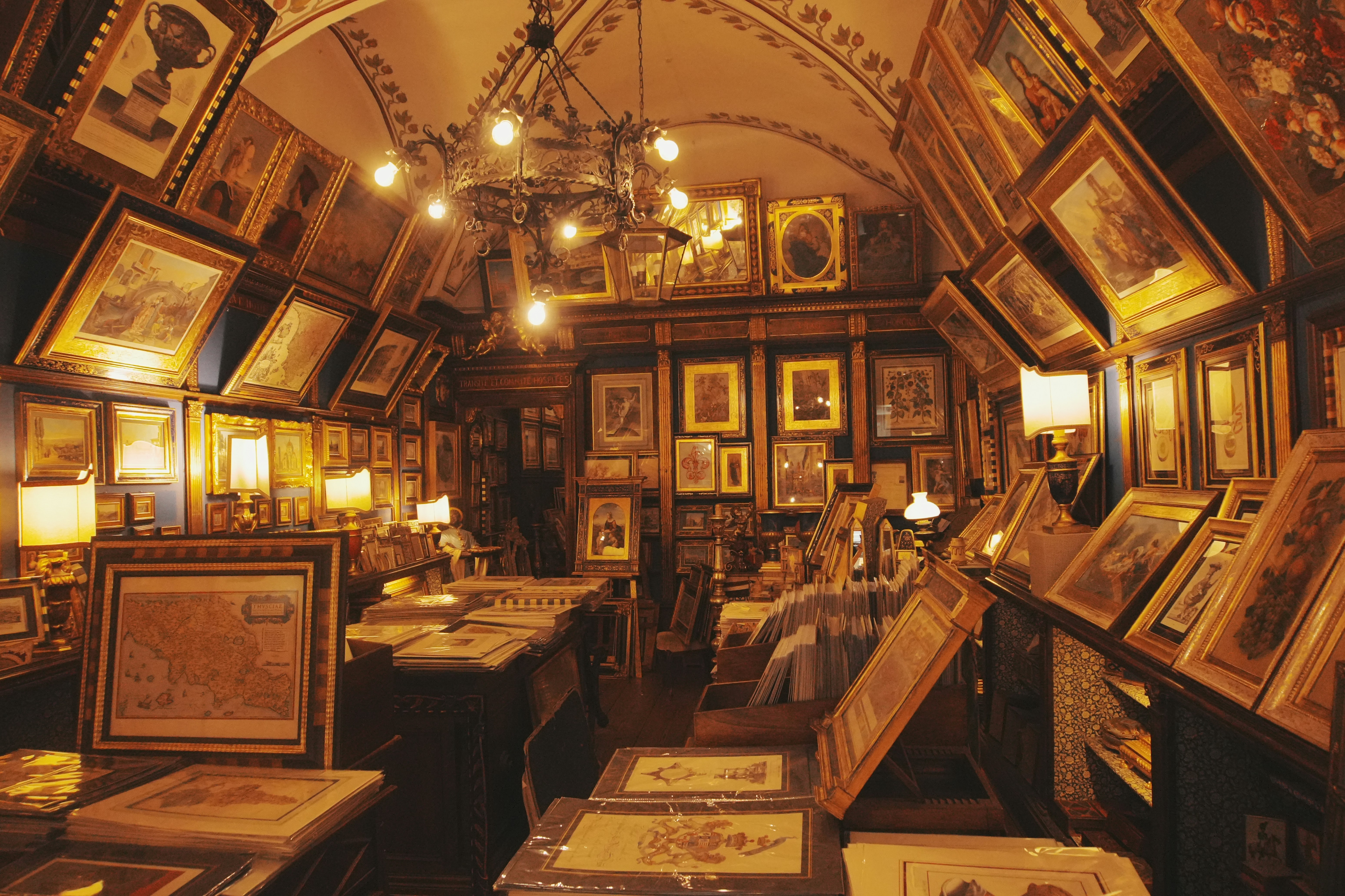 Antique shop filled with framed art and maps.
