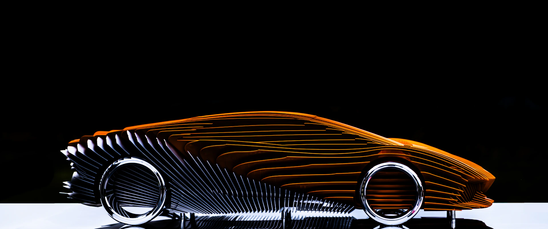 Abstract sculpture of a car with orange and silver details.