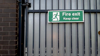Green fire exit sign on metal gate