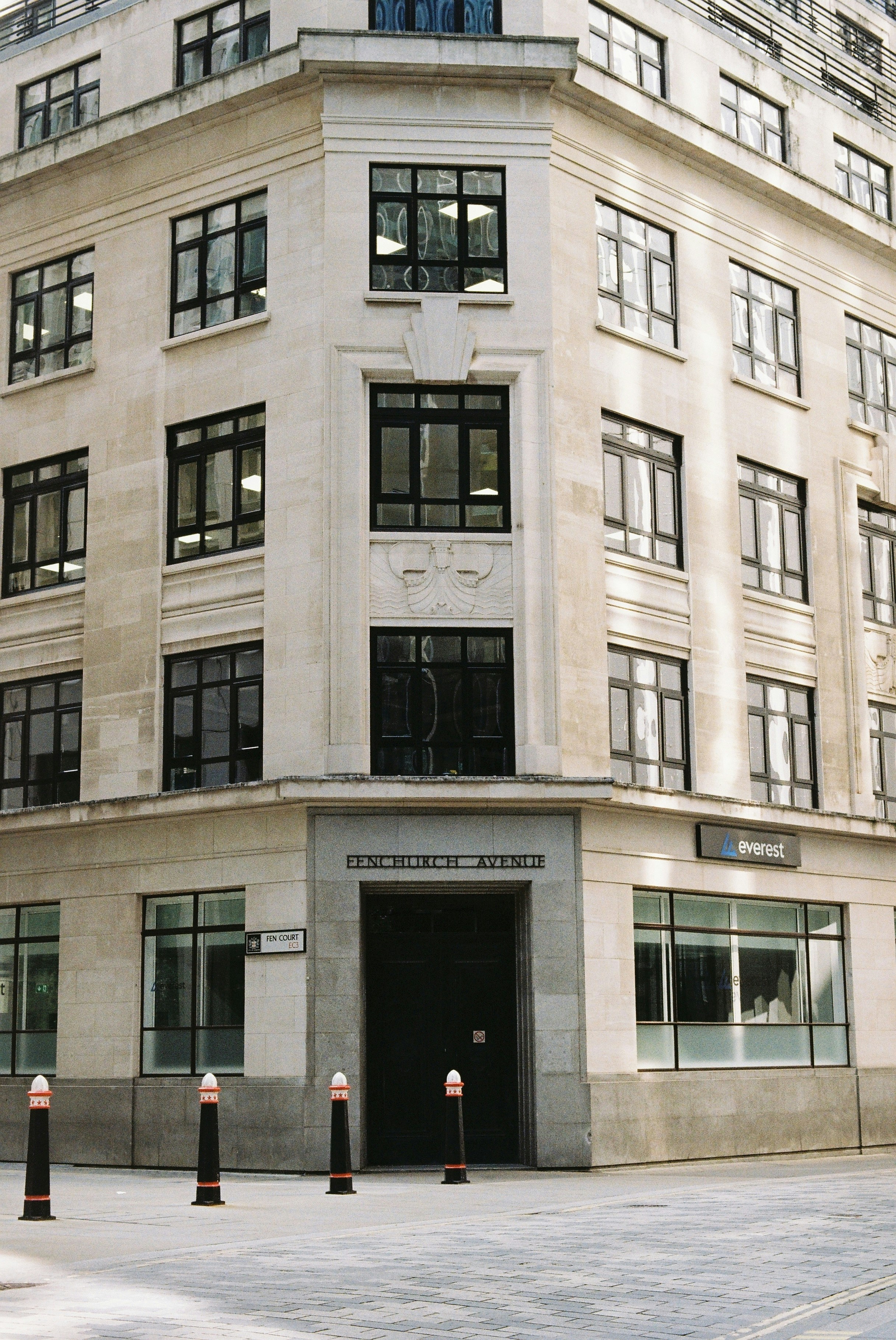 Coin d’un bâtiment en pierre avec de nombreuses fenêtres.