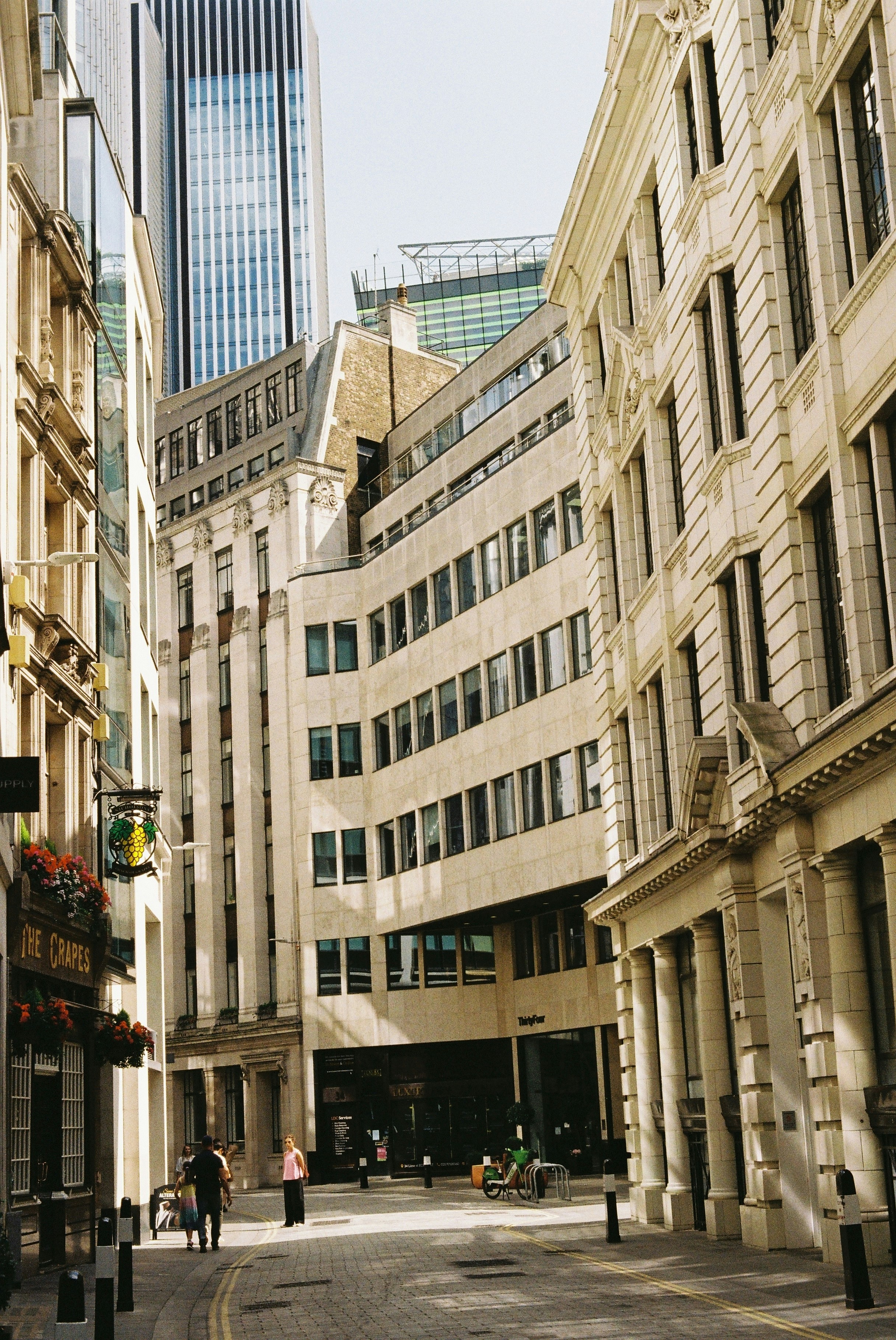 Les gens marchent dans une rue étroite entre les bâtiments.