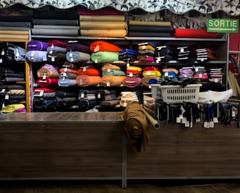 Rolls of colorful fabric displayed on shelves in a store.