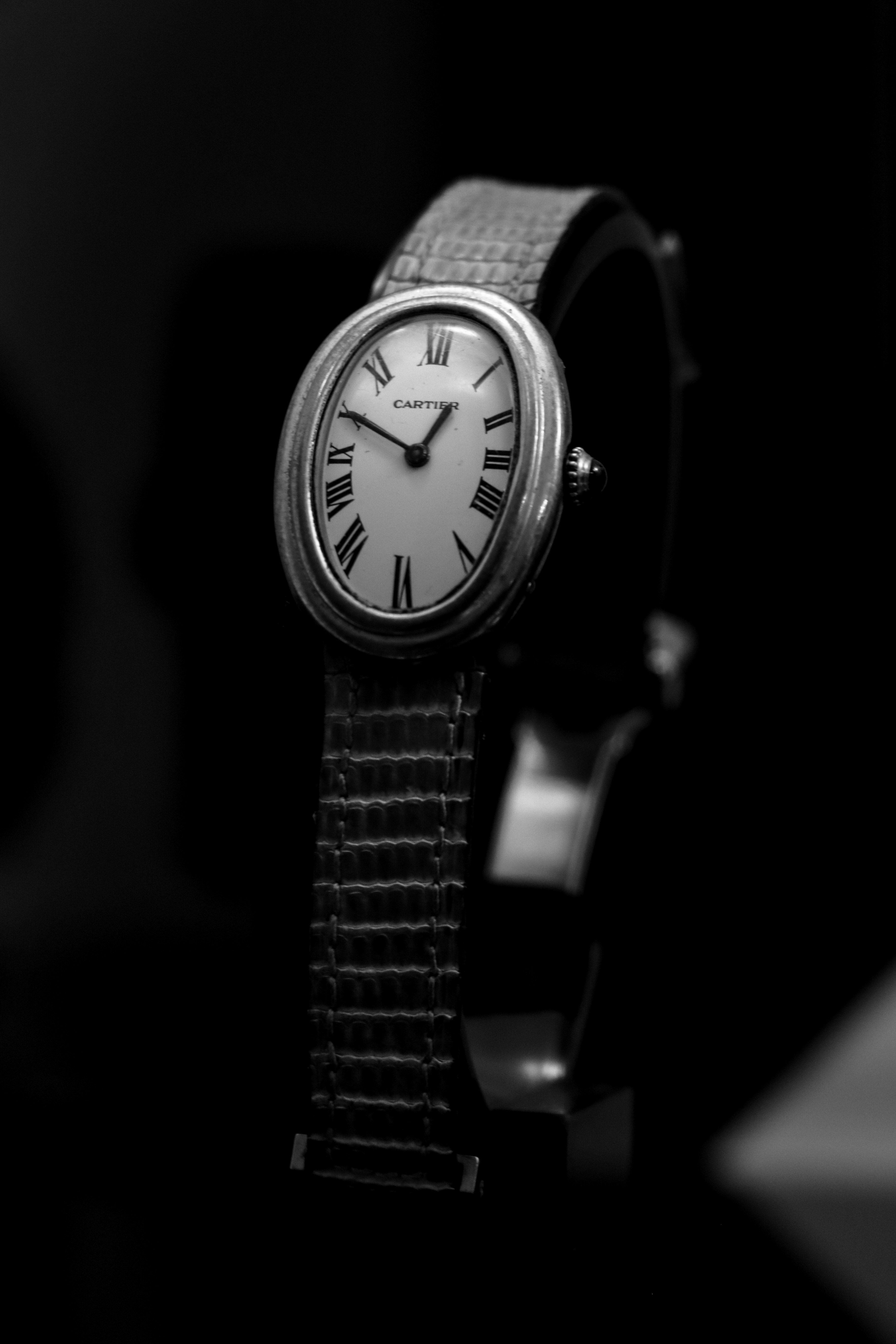 An elegant oval wristwatch with a leather band.