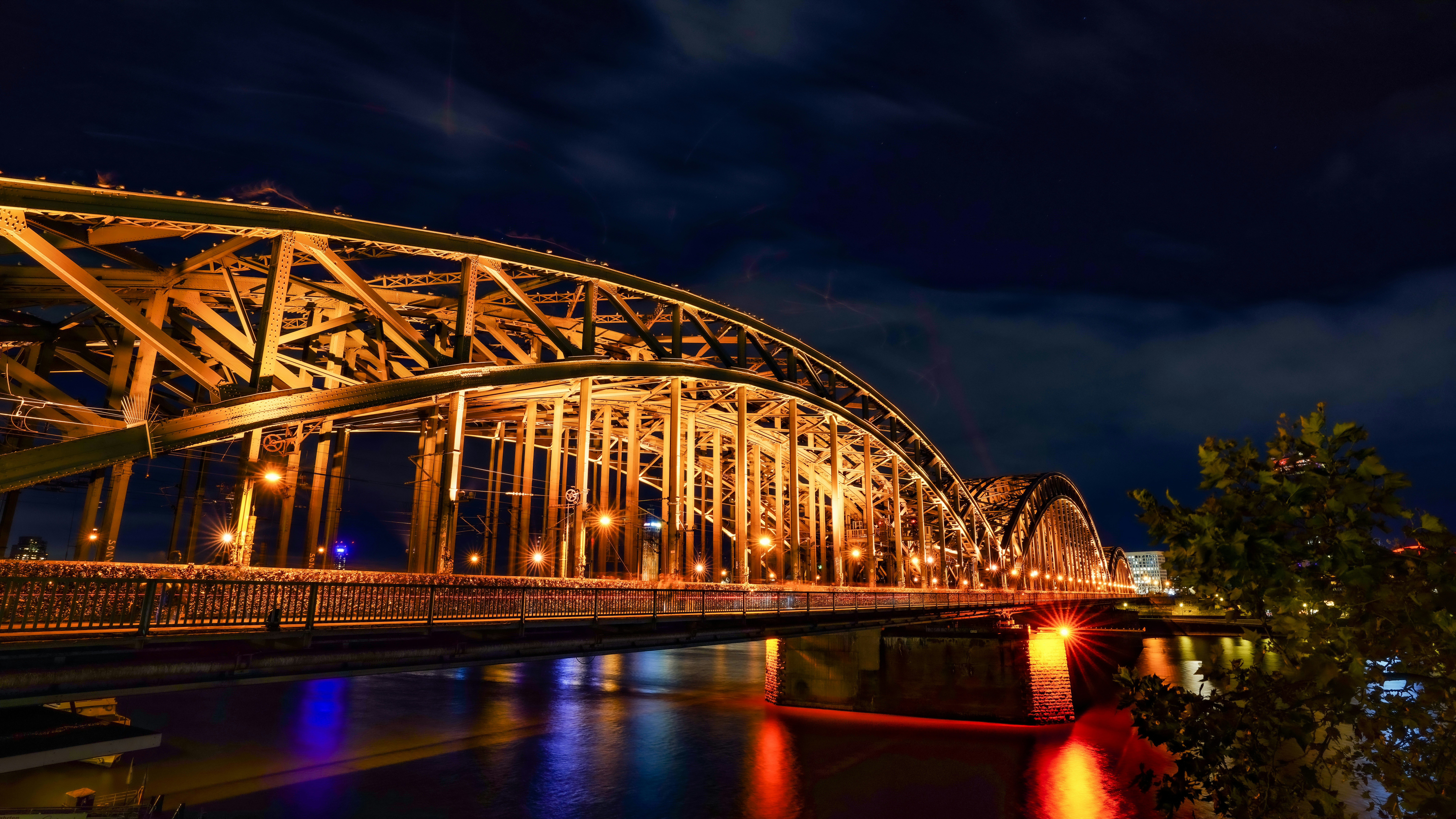 Illuminated steel bridge at night over water