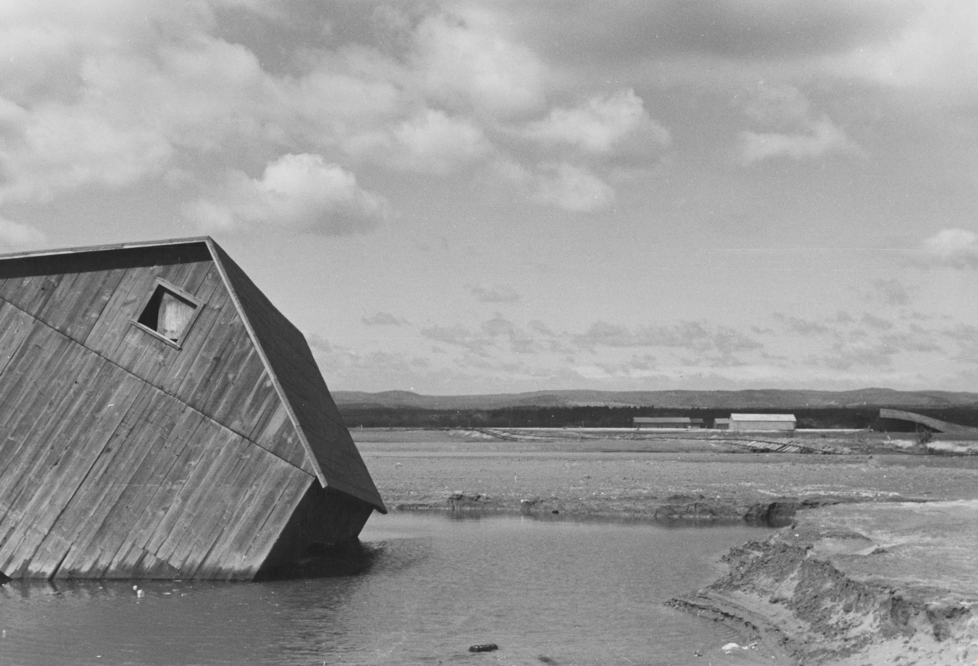 A tilted wooden structure partially submerged in water