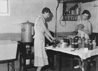 Two women canning food in a basement