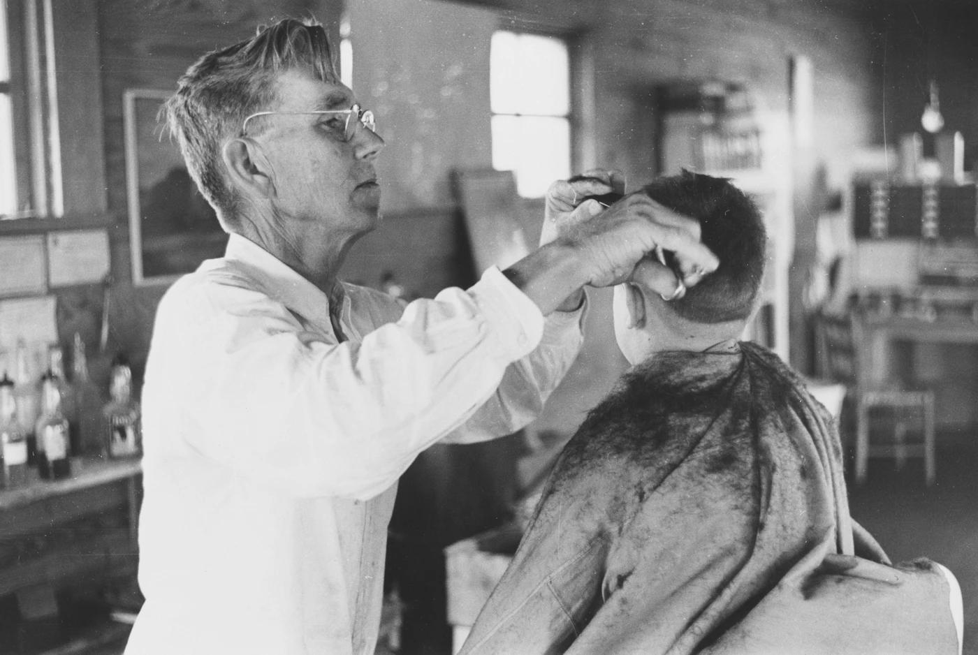 A barber working through a client's hair with a comb