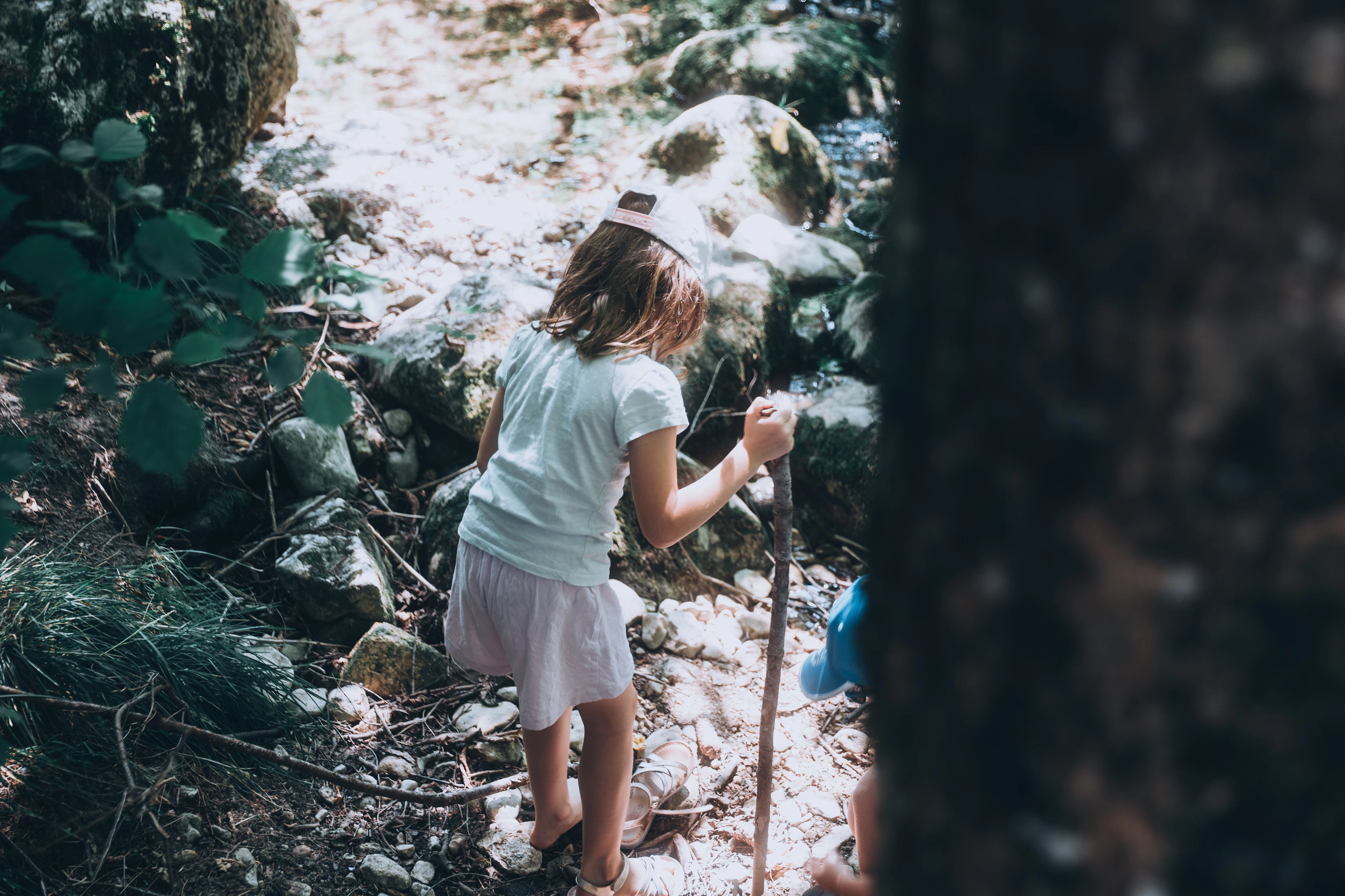 A girl hiking on a rocky forest path