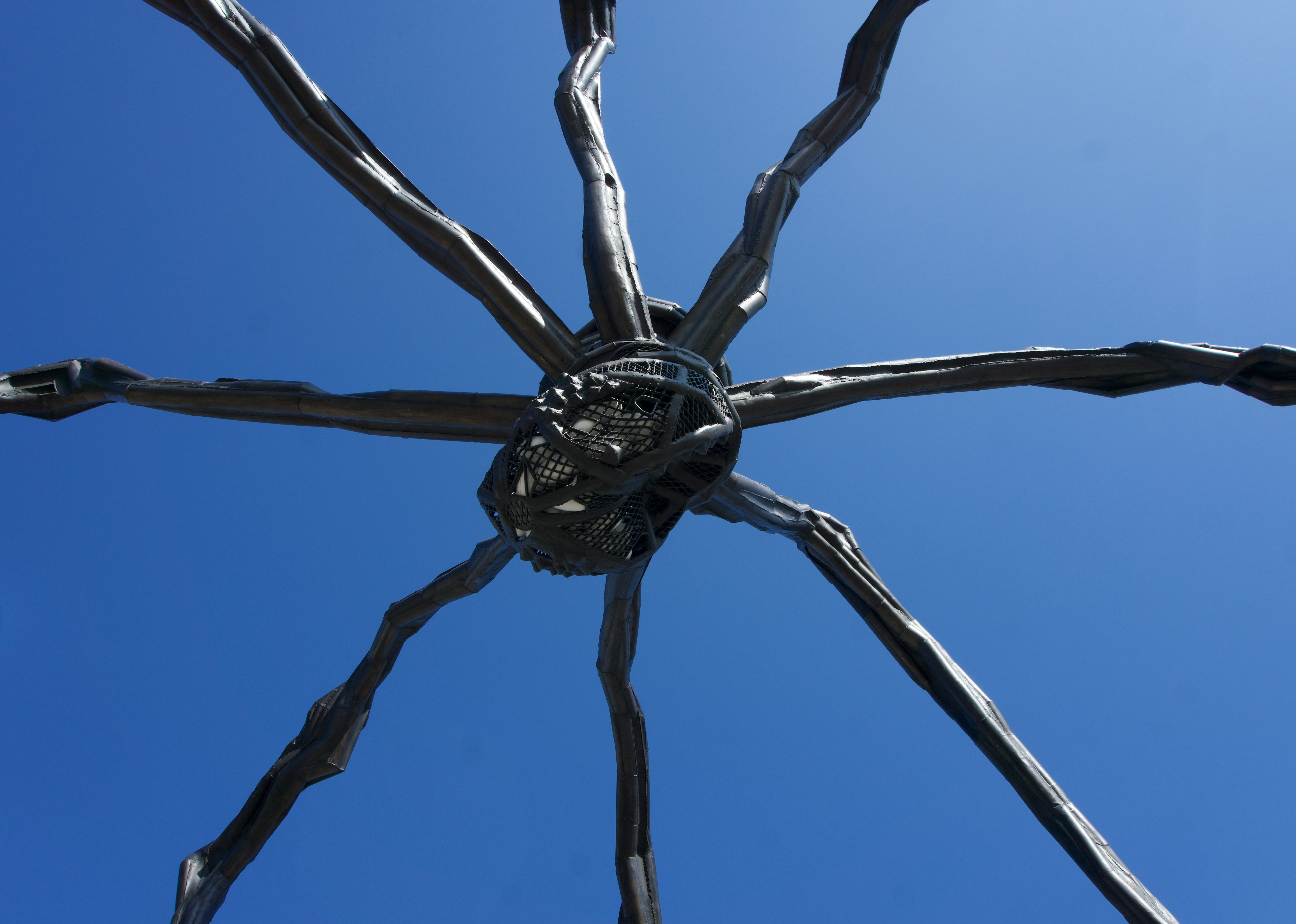 Abstract metal sculpture against a clear blue sky