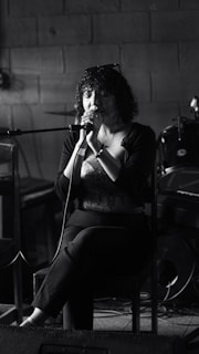 Woman singing into a microphone on stage