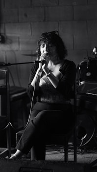 Woman singing into a microphone on stage