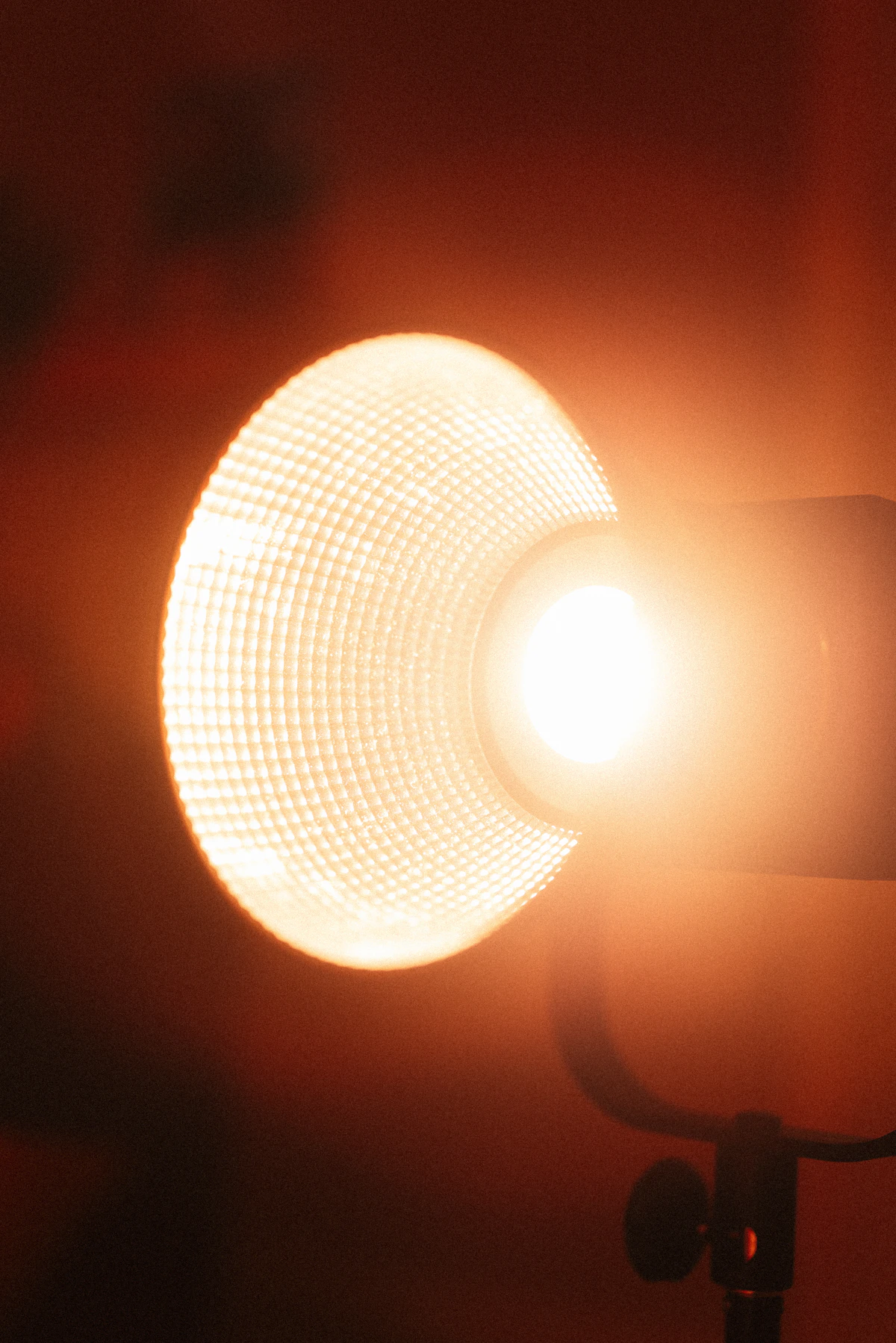 A round studio light glowing warm orange