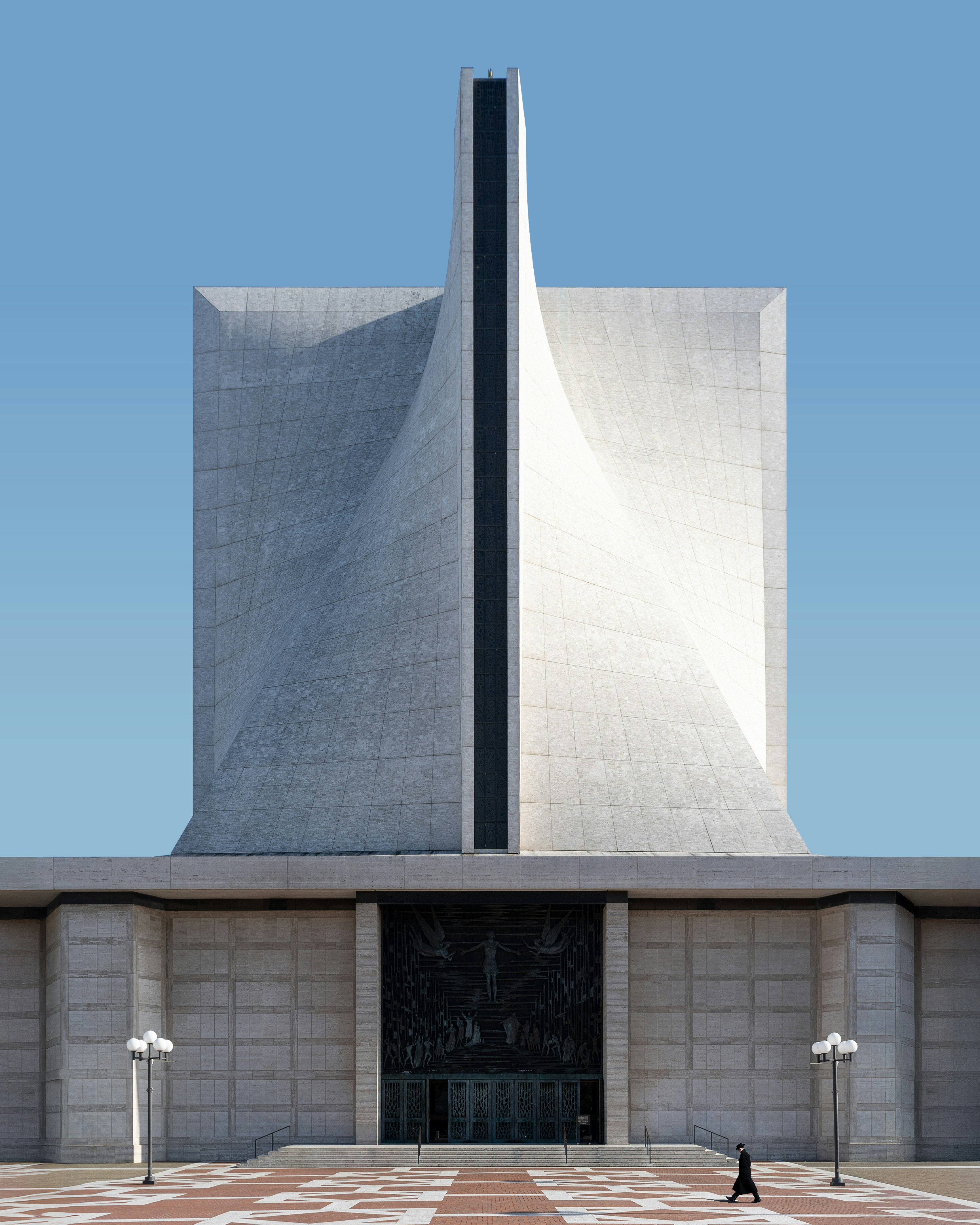 Catedral moderna con fachada geométrica de hormigón y cielo azul