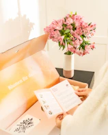 Pink flowers in vase with open delivery box