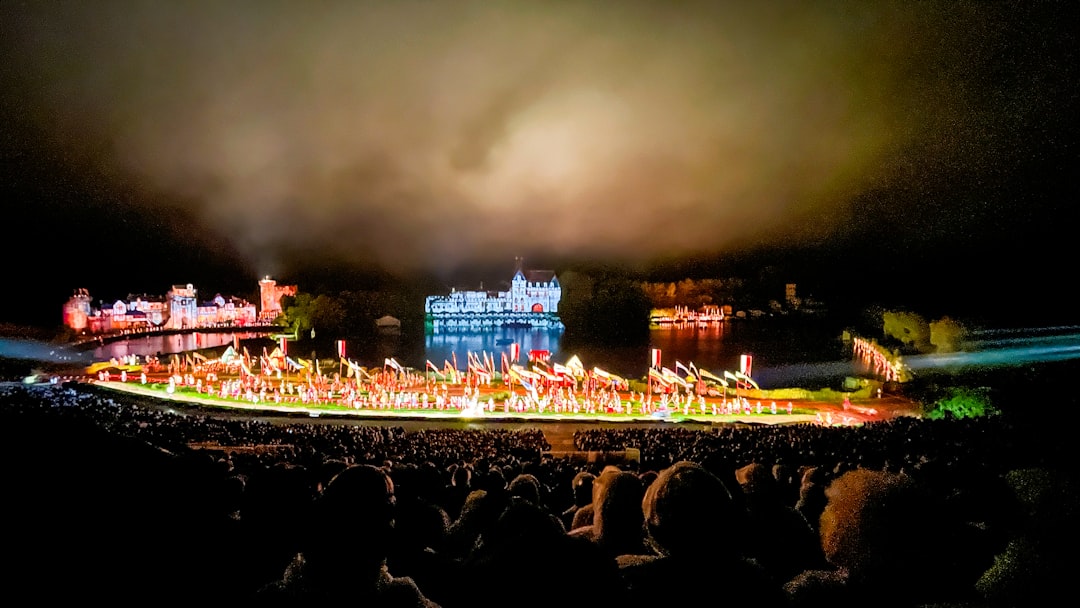 Large outdoor performance with illuminated buildings and crowd.
