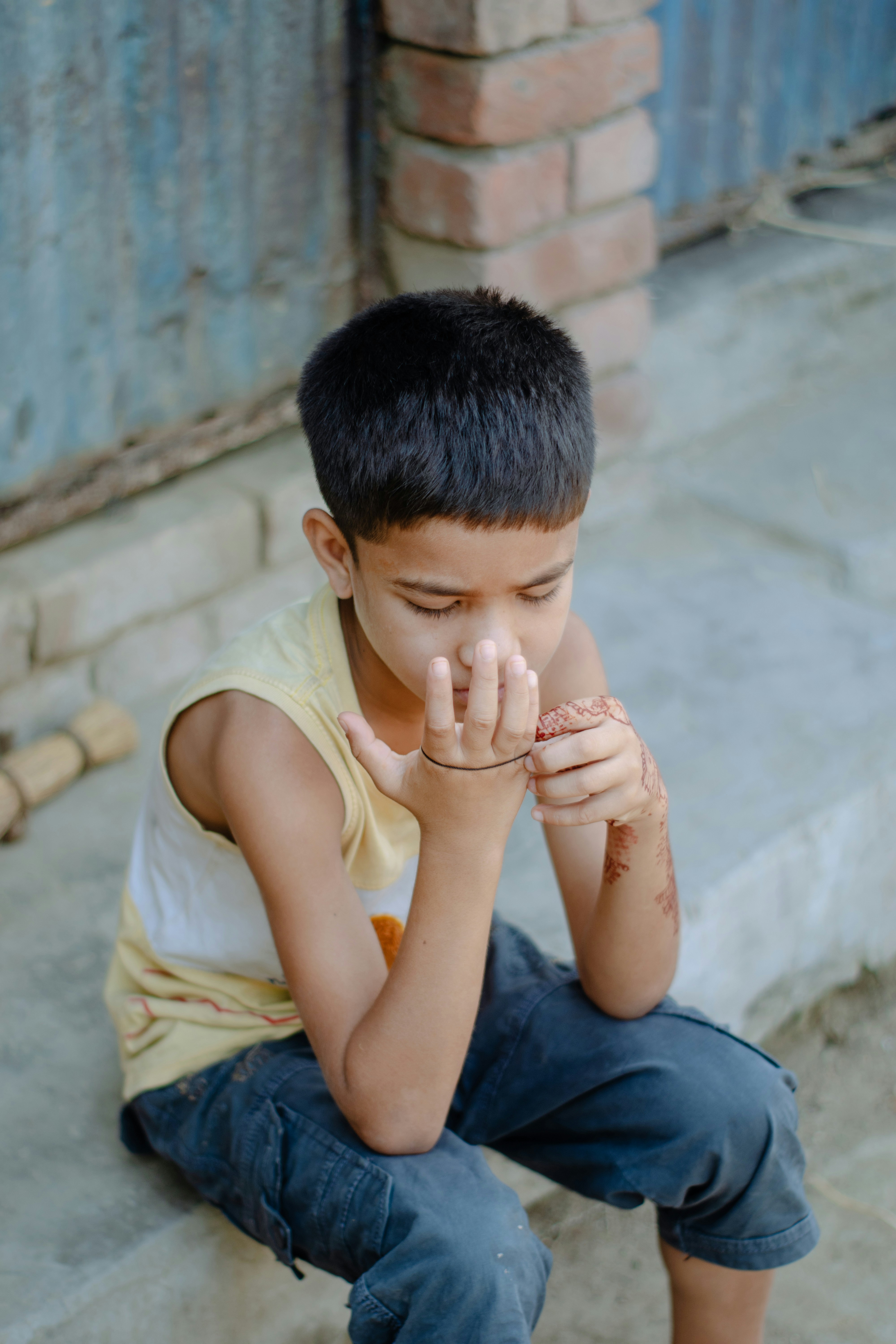 Young boy looking at his hand with henna