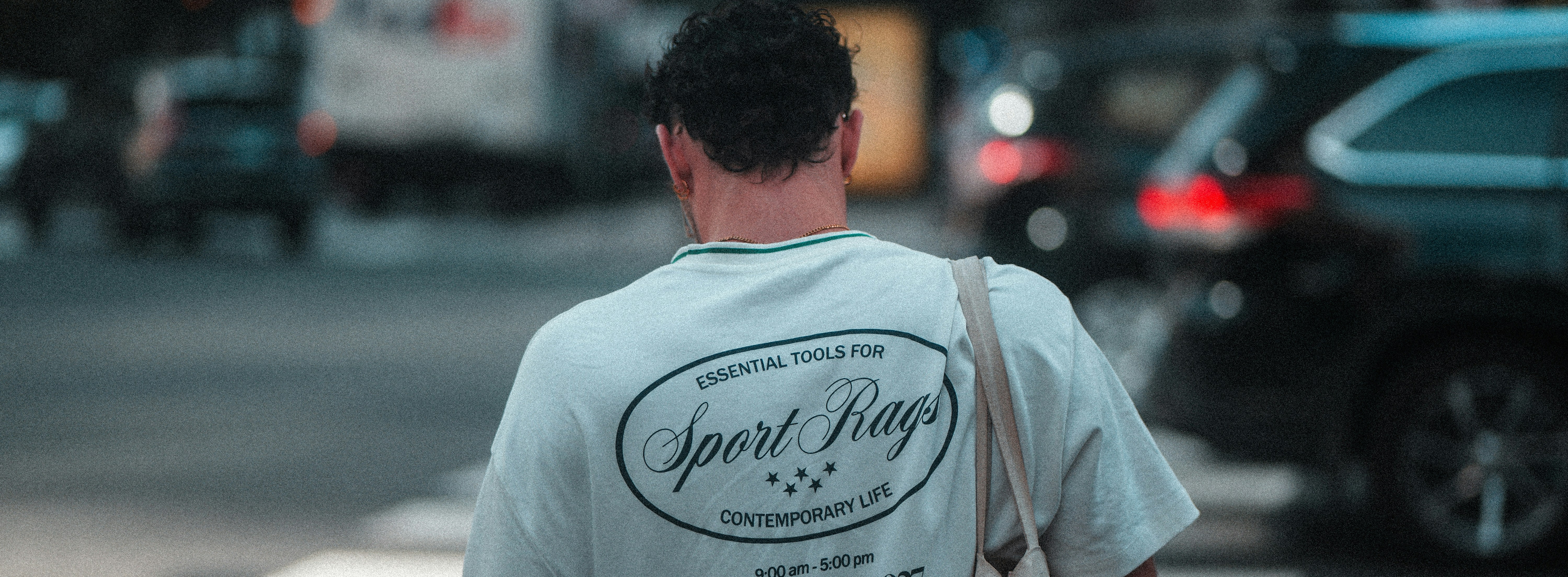 Man walking across street with cars in background.